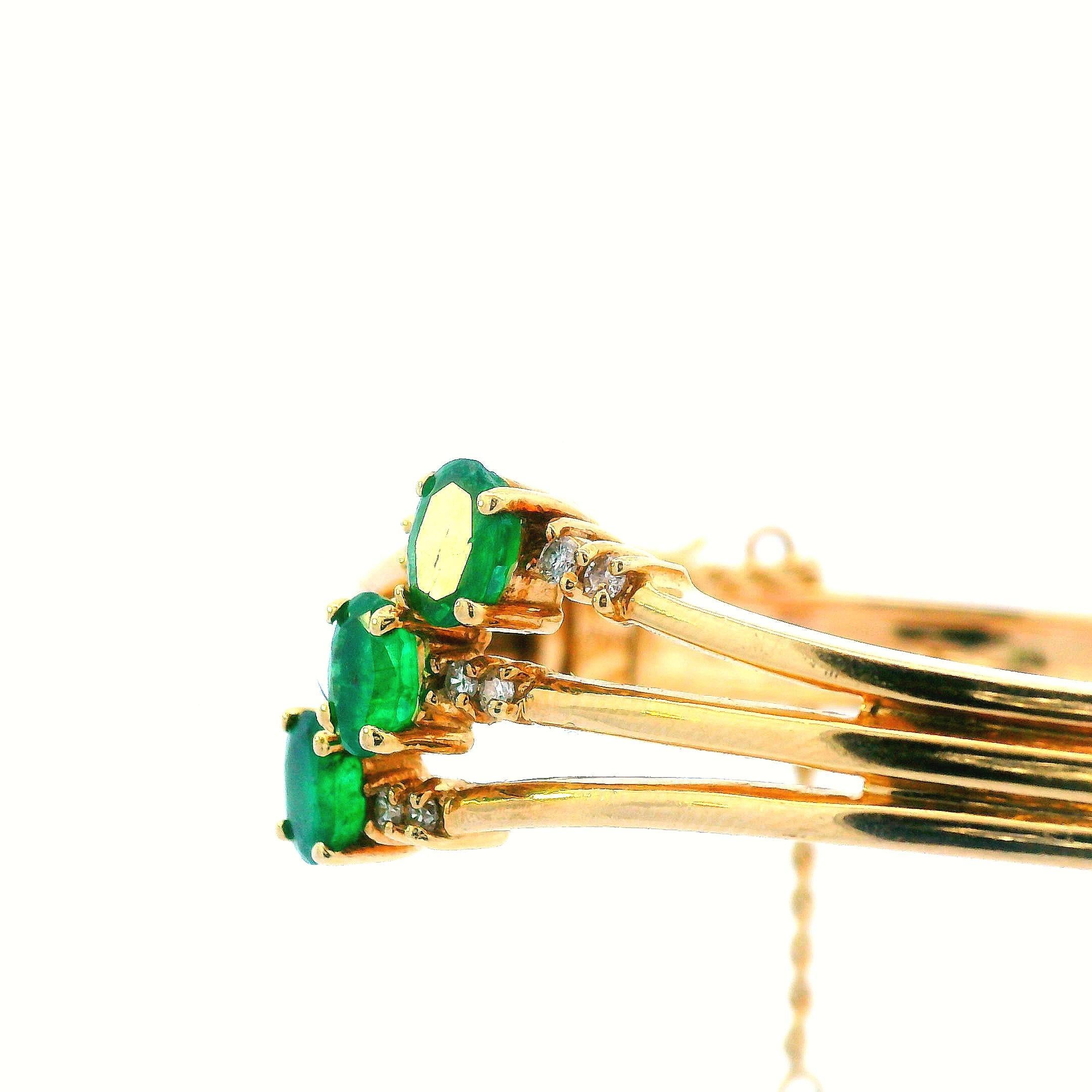 Ce charmant bracelet des années 1960 est réalisé en or jaune 14k et contient à la fois des émeraudes et des diamants. Le bracelet en or jaune 14k est composé de trois bandes d'or individuelles qui se rejoignent pour créer une bande solide. Ce thème