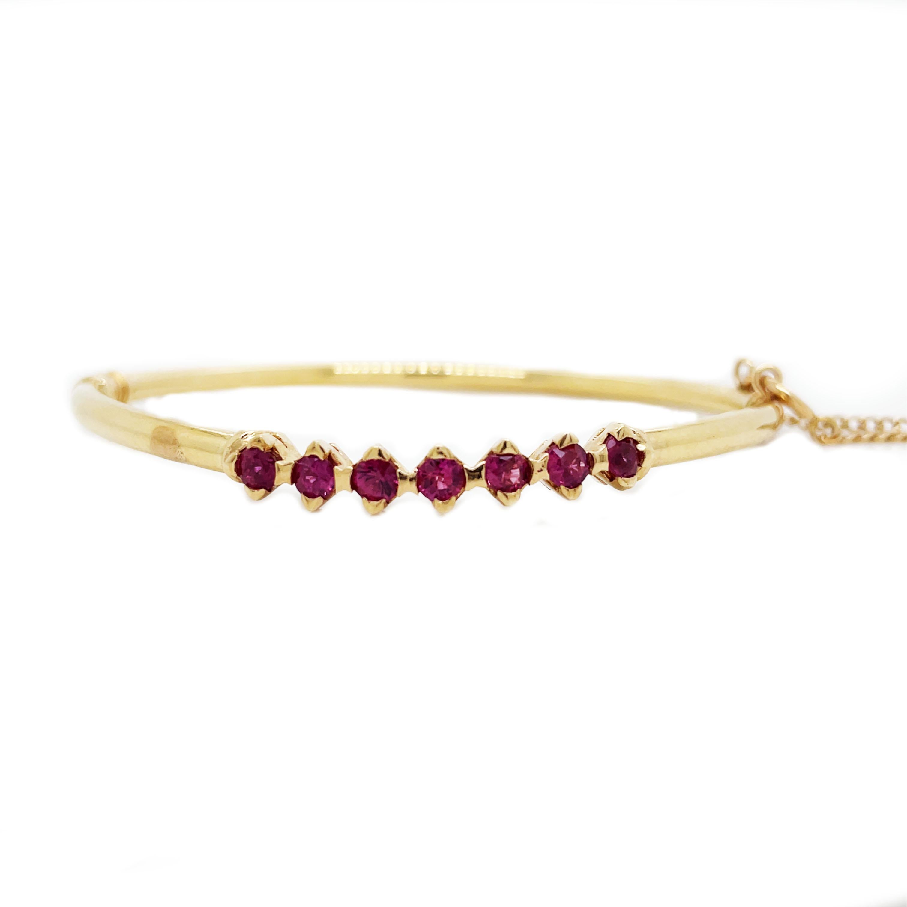 This is a beautiful 1960s bangle crafted in 14K yellow gold that showcases bright and vibrant rubies! The bangle is hinged which allows for ease of wear and is extremely comfortable for everyday wear! In this chic, sophisticated, and classic
