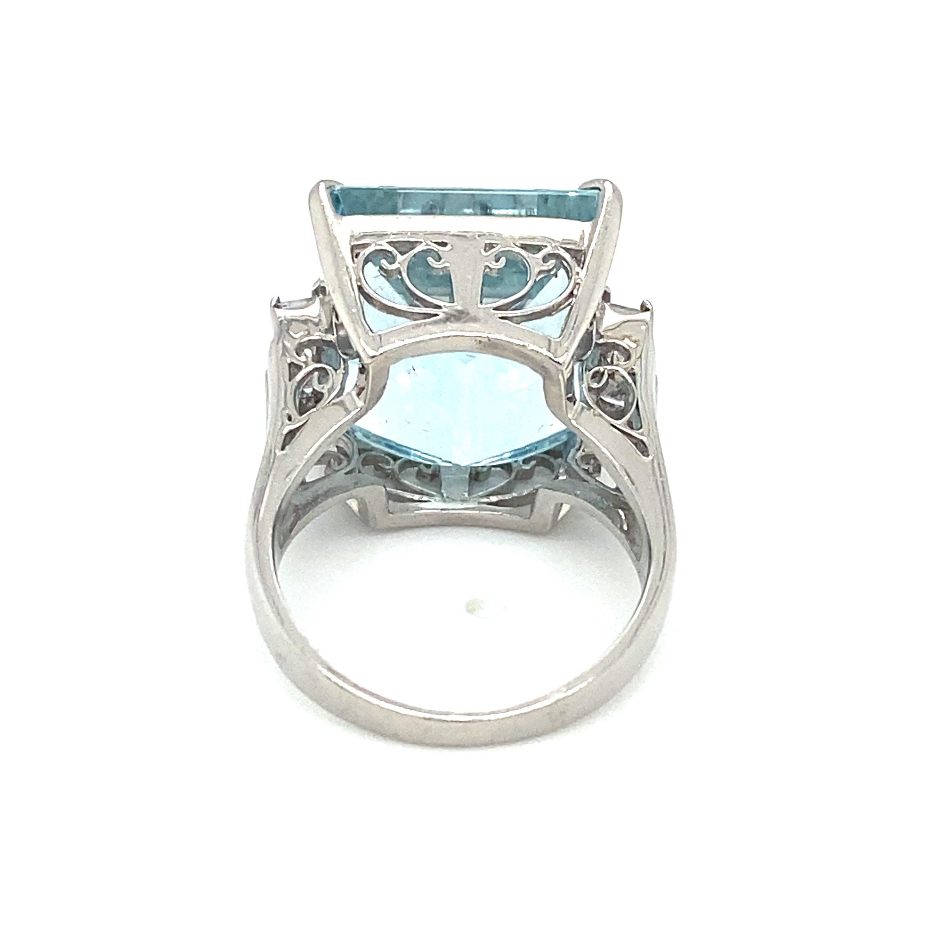 Item Details: This stunning ring has a large square aquamarine with accent side diamonds, set in platinum. It dates back to the 1960s and features Asscher cut accent diamonds. It has a very rich and ornate look! The gallery design is intricate and