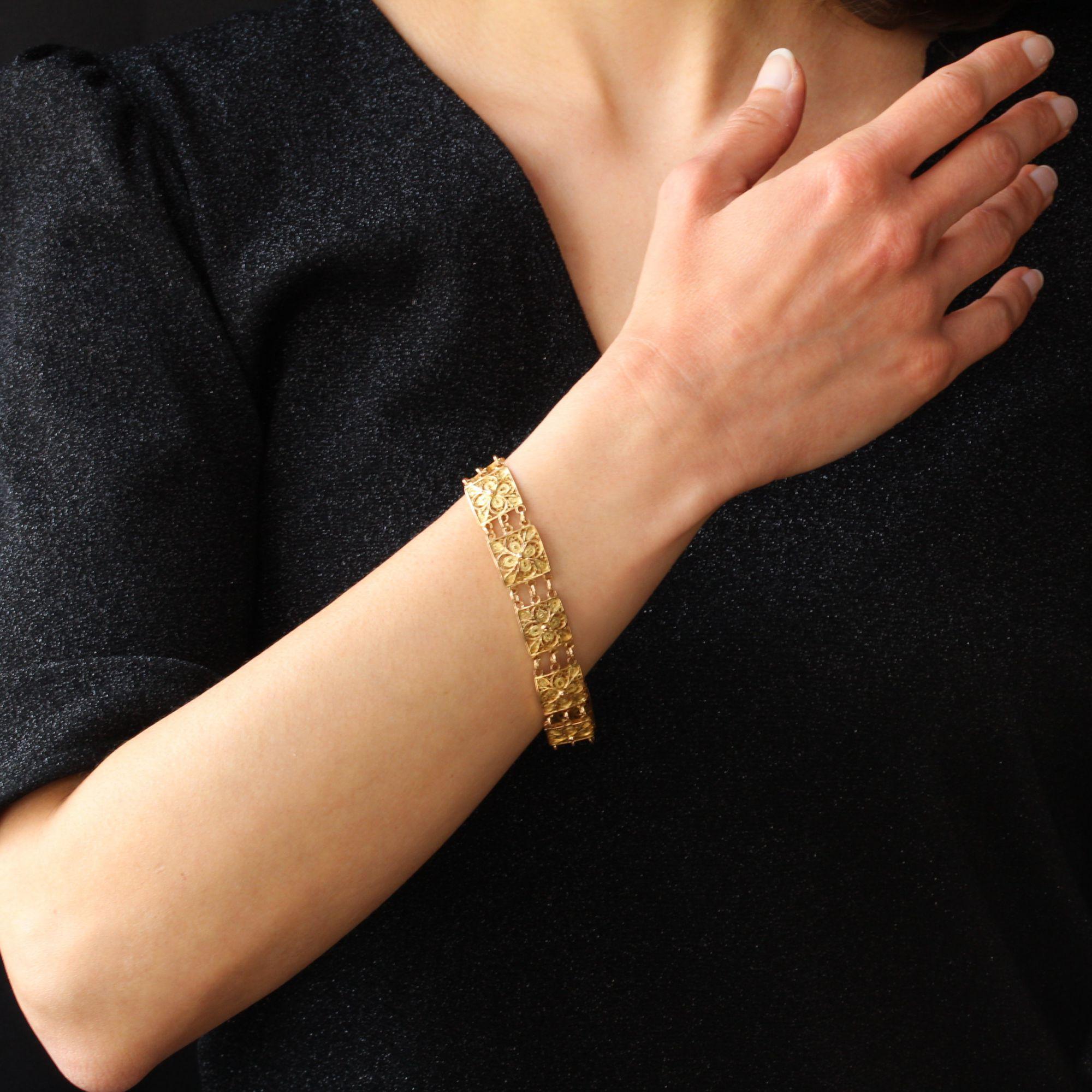 Bracelet in 18 karat yellow gold.
Beautiful retro bracelet, it consists of 10 square shape links, openwork filigree, attached to each other by rings. The clasp is ratchet with safety chain.
Length : 19 cm, width : 13.1 mm, thickness : 3.2 mm.
Total
