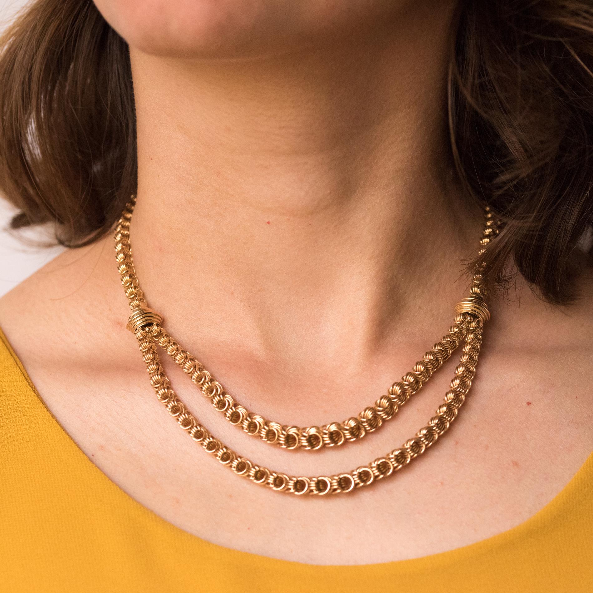 Halskette aus 18 Karat Roségold.
Prächtige Retro-Halskette, sie besteht aus einem Geflecht aus verflochtenen Ringen aus Roségold, das Muster besteht aus 2 Reihen unterschiedlicher Länge für einen drapierten Effekt am Dekolleté. 2 gadronierte Muster