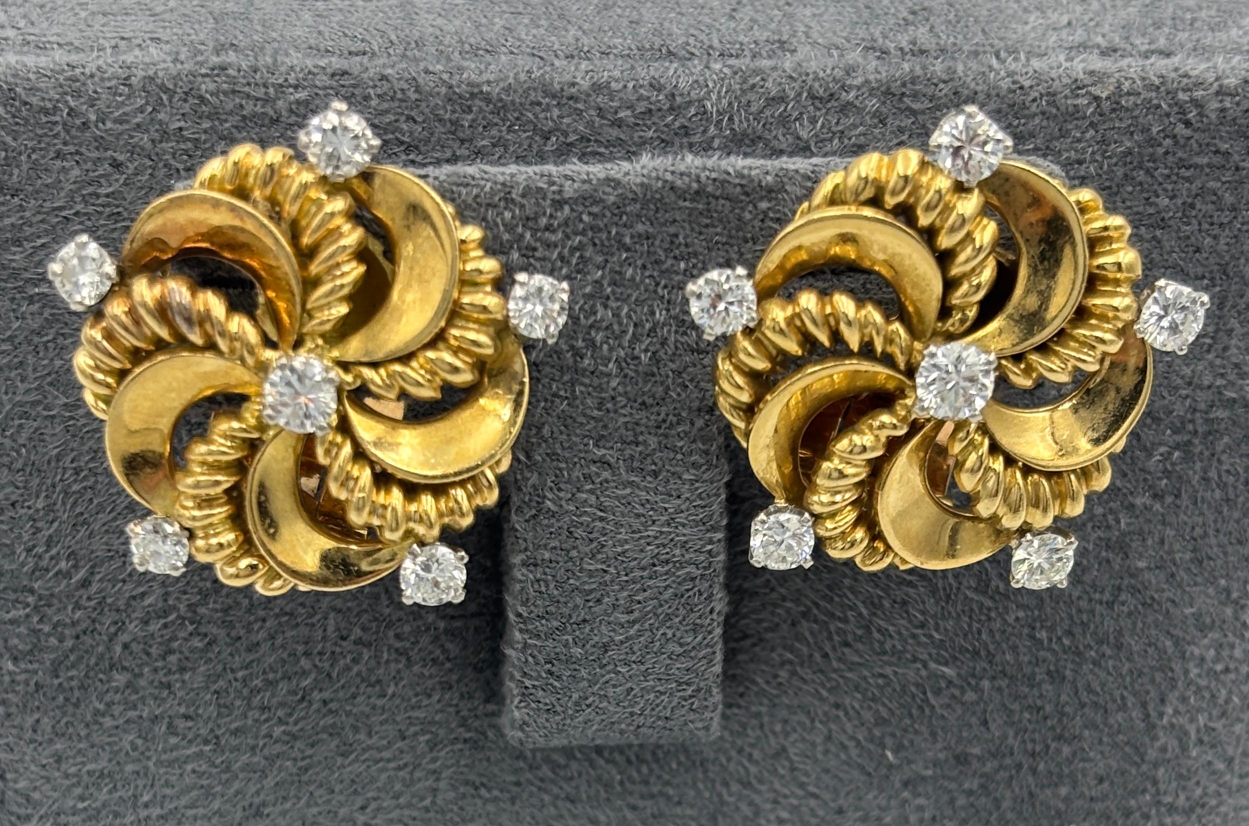 Cette ravissante paire de boucles d'oreilles à clip de Pery et Fils date des années 1960. Fabriquées en France en forme de tourbillon, les boucles d'oreilles sont ornées d'un total d'environ 1 carat de diamants ronds. Confortables à porter de jour