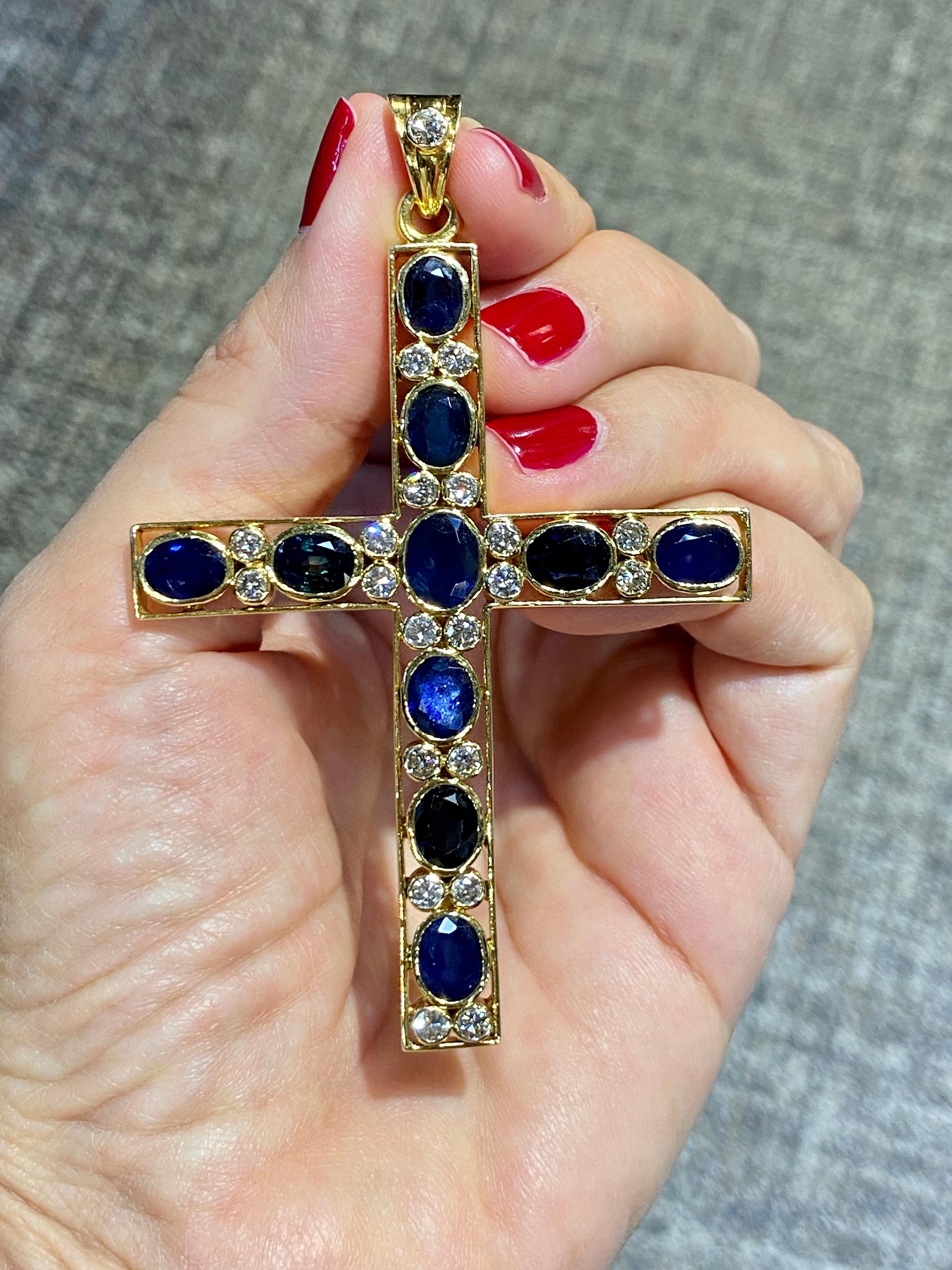 This spectacular 1960's cross is made of 18k gold and contains 10 oval faceted sapphires weighing approximately 15 carats and 21 round cut diamonds weighing approximately 1.5 carats. It is a most elegantly striking pendant.
