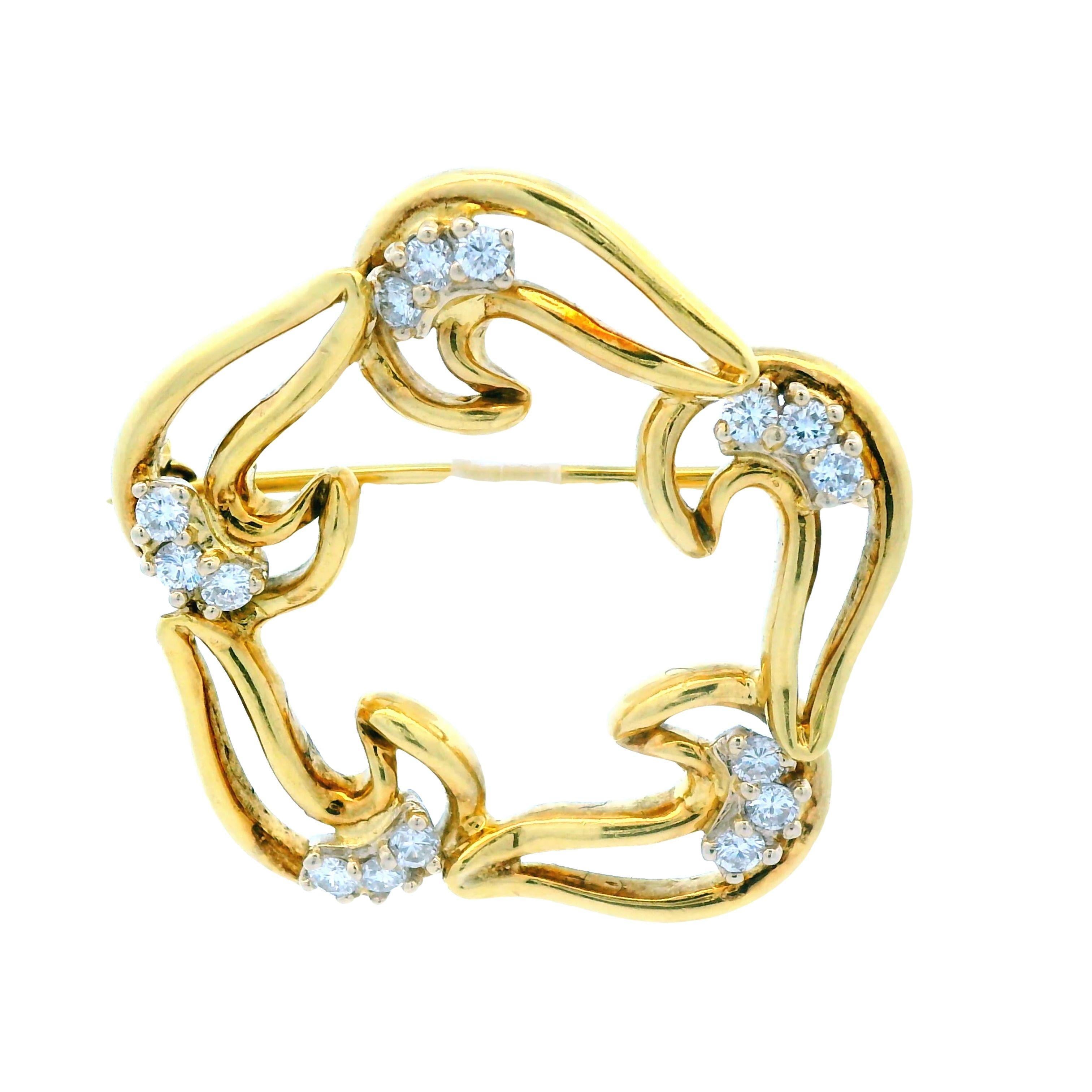 This is a lovely 18k yellow gold and diamond pin from the 1960s.  Although this pin utilizes negative space and appears to be light and airy, this pin is solid and dense. This pin can be worn and styled in many different ways due to its unique,