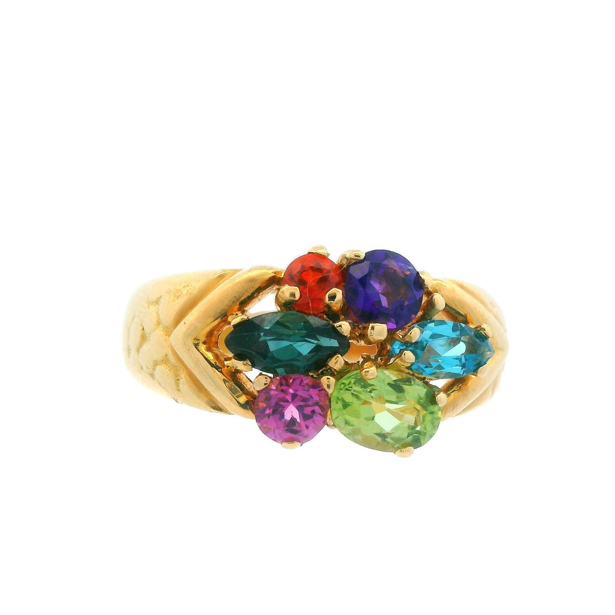 This is a stunning vintage ring signed by famed H. Stern, crafted in rich 18K yellow gold, showcases a dazzling group of vibrant gemstones. This ring is set with six multicolored gemstones in various cuts and set in a unique pattern. The ring