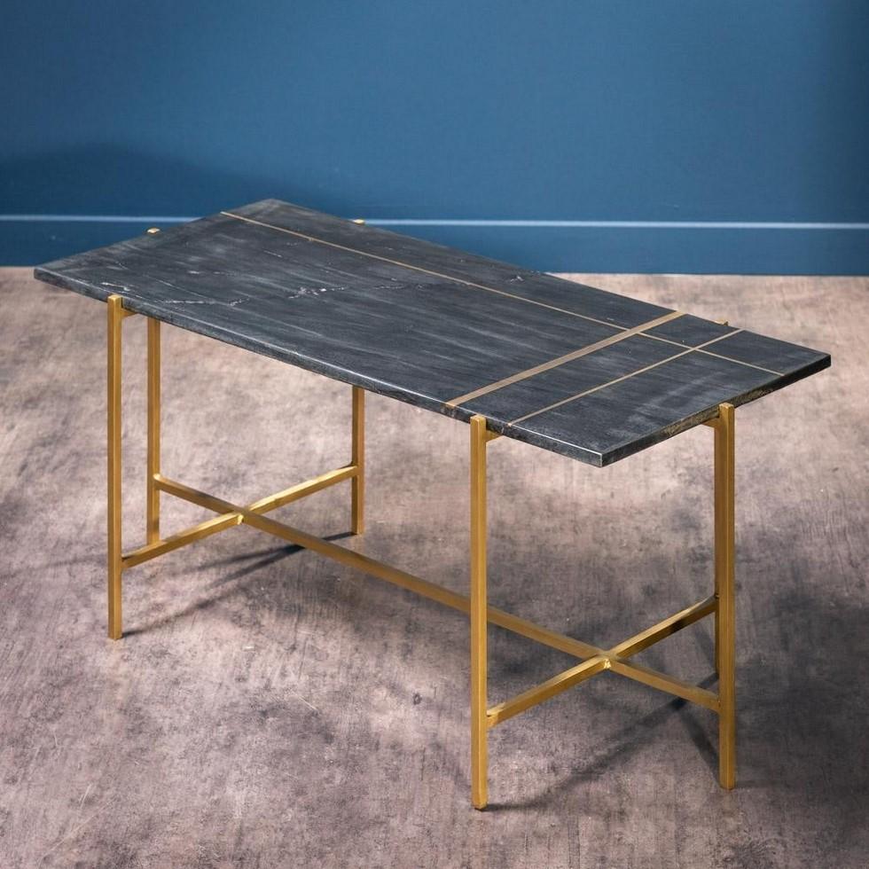 1960s-1970s design style rectangular coffee table consisting of a graphic and geometric brass metal feet with a rectangular black marble tray with brass inlay.