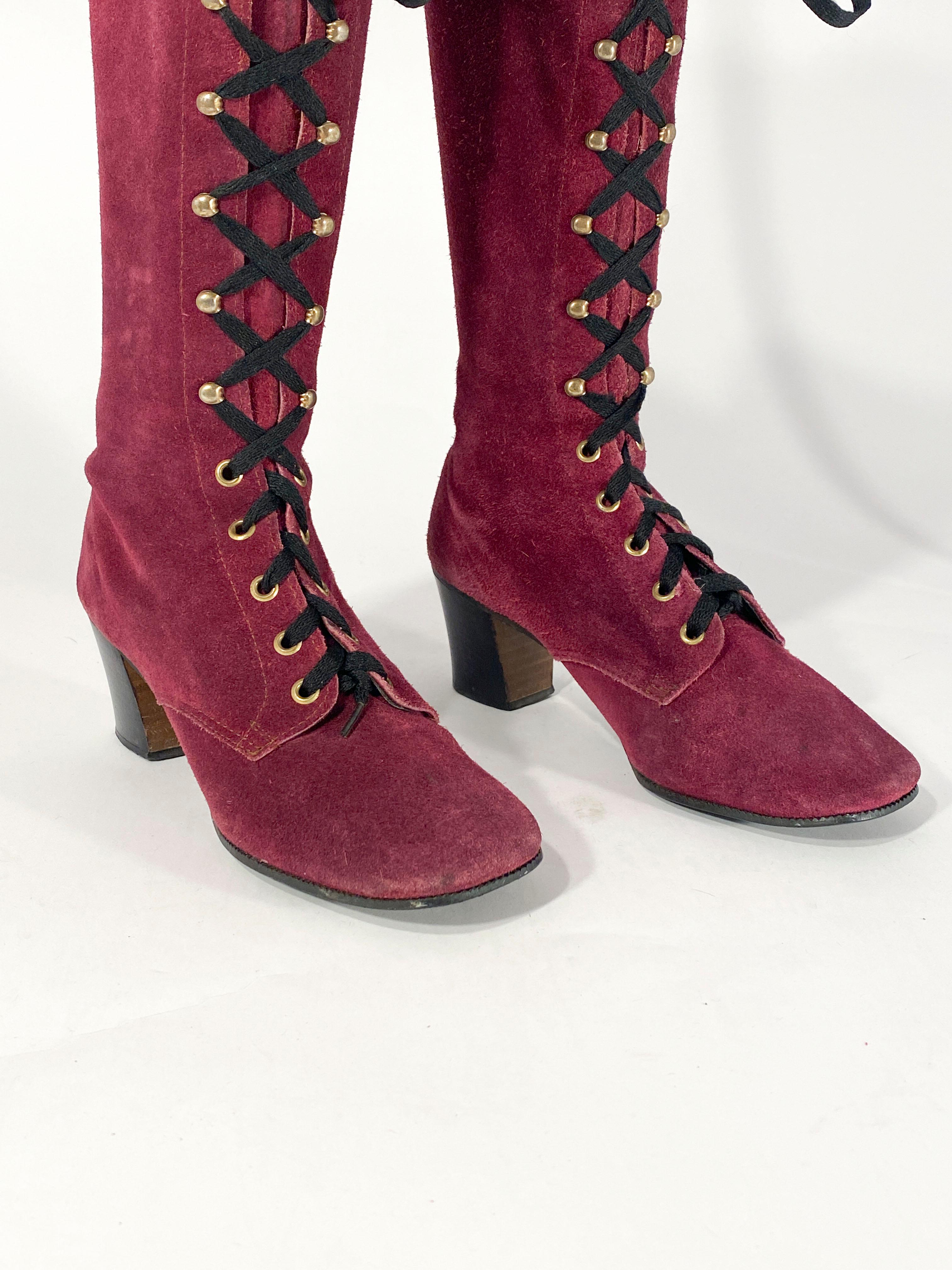 Late 1960s to early 1970s Purple suede lace-up knee-high boots with stacked heel, nickel grommets, lace hoods and black laces. 
