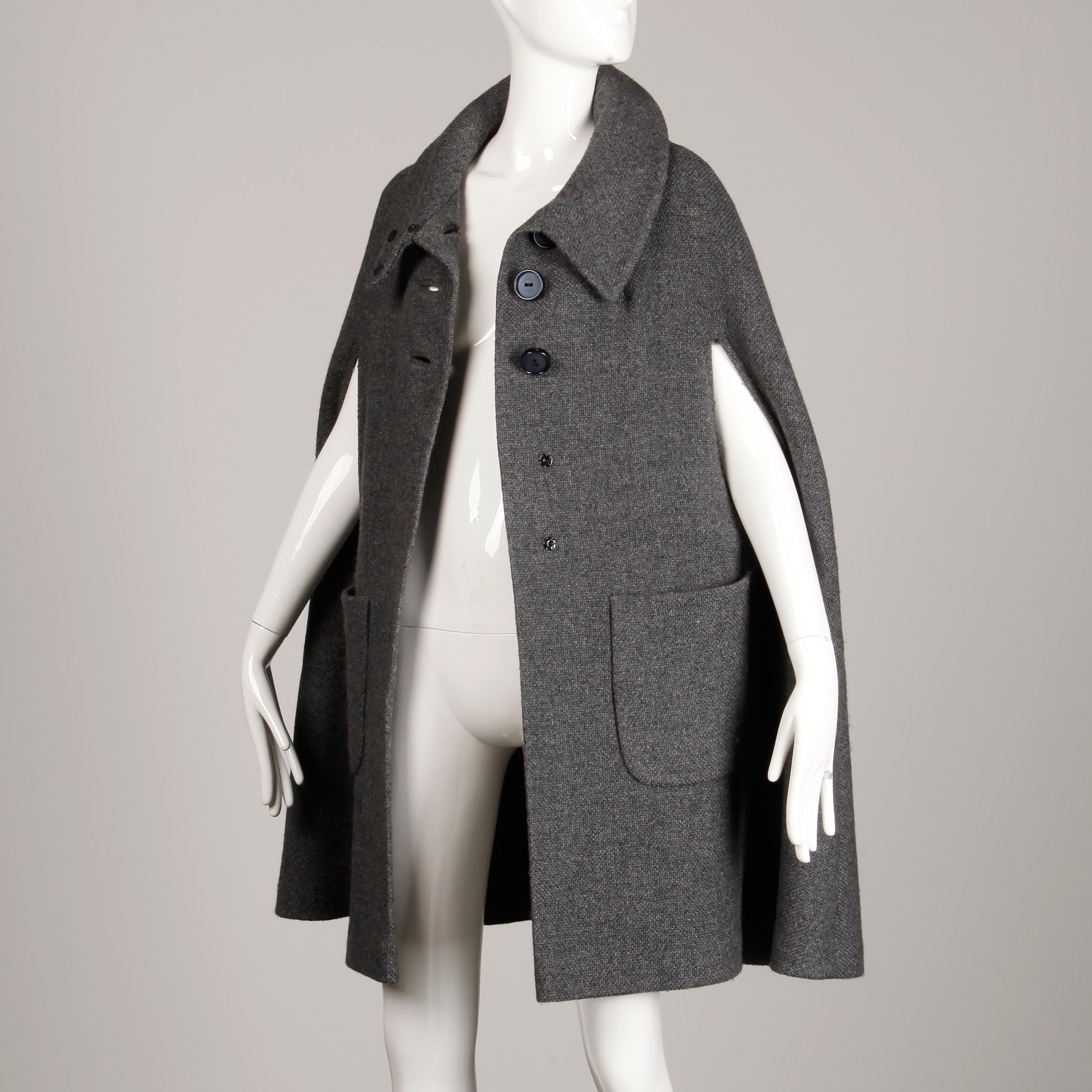 Gorgeous vintage gray wool cape coat with a military-inspired cut from the 1960s-1970s. Fully line with front button an snap closure. Front patch pockets. Fits most sizes small-large on account of the free shape. Measured flat across the chest the