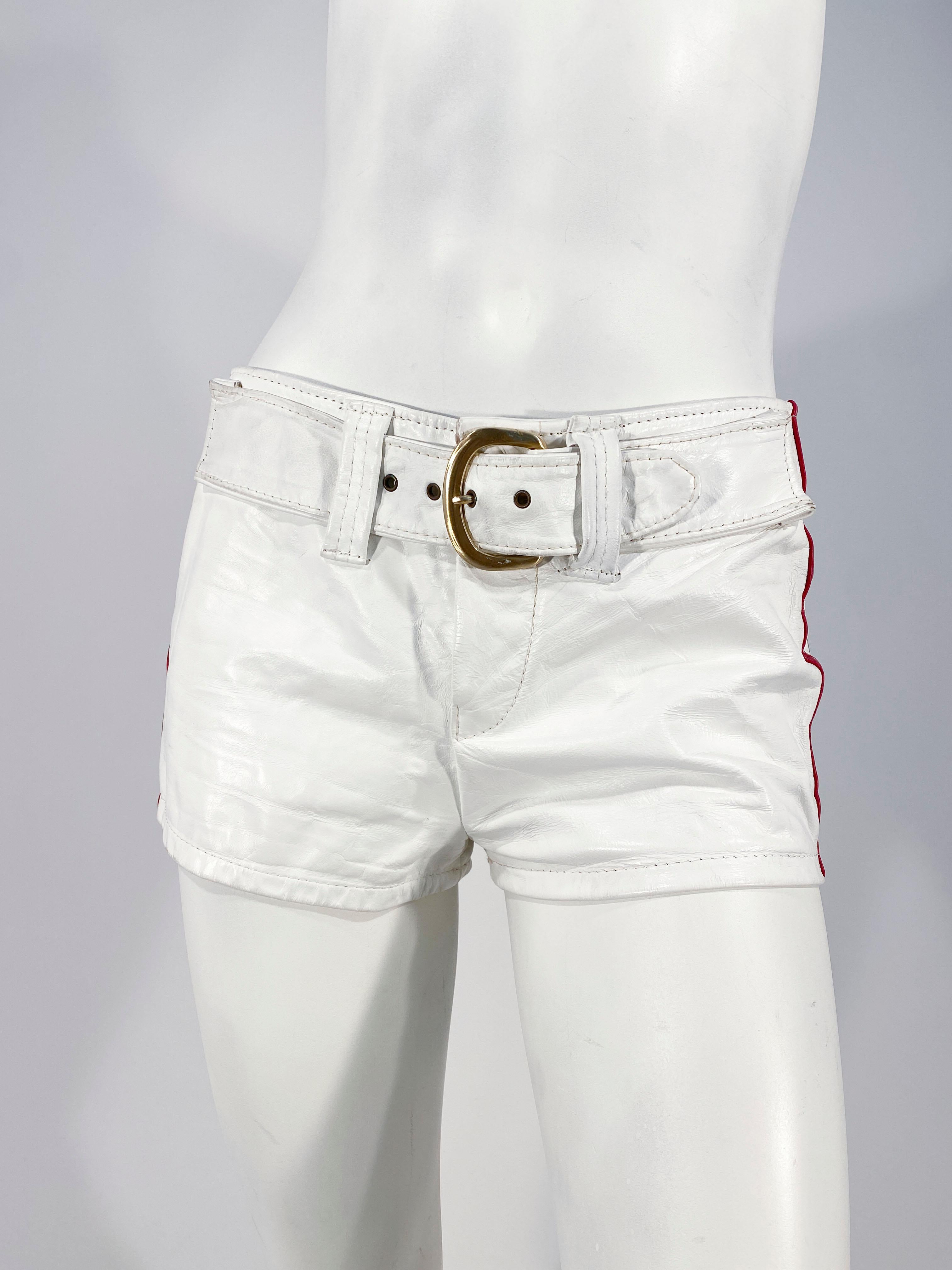 Late 1960s to early 1970s white leather Go-go leisure shorts with Navy blue and read leather stripes on each side finished with white topstitching. The metal zip fly also has a wide applied belt with an oversized bras metal buckle. The entire 