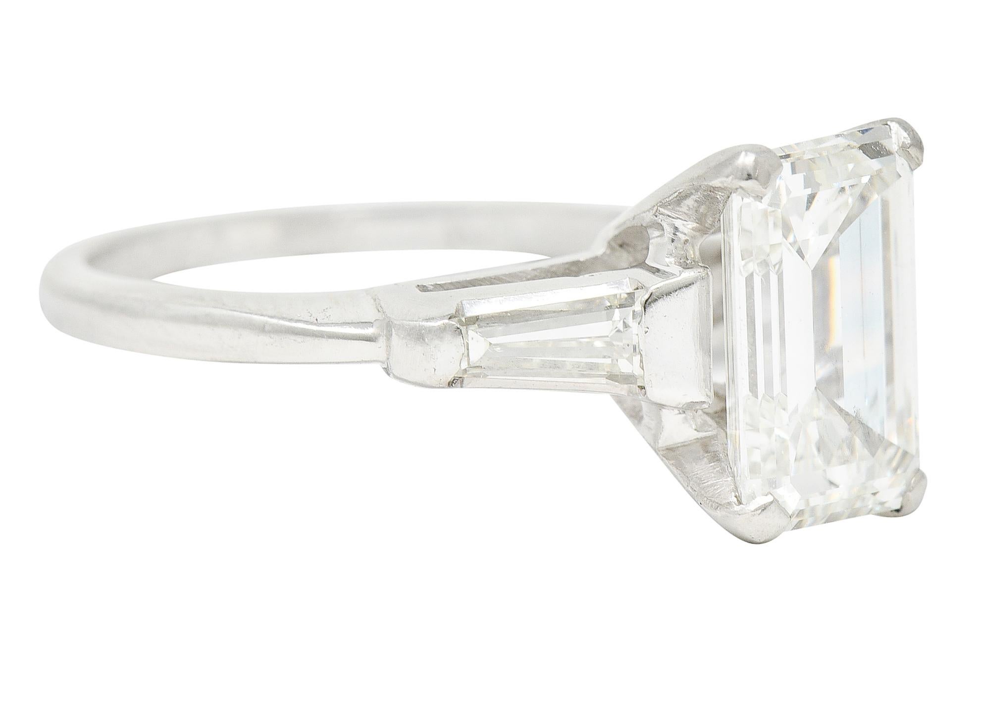 In der Mitte ein Diamant im Smaragdschliff mit einem Gesamtgewicht von 2,04 Karat - Farbe H und Reinheit VS2. Zackenfassung im Korb und flankiert von Kathedralschultern mit spitz zulaufenden Diamanten im Baguetteschliff. Bar gesetzt und wiegt etwa