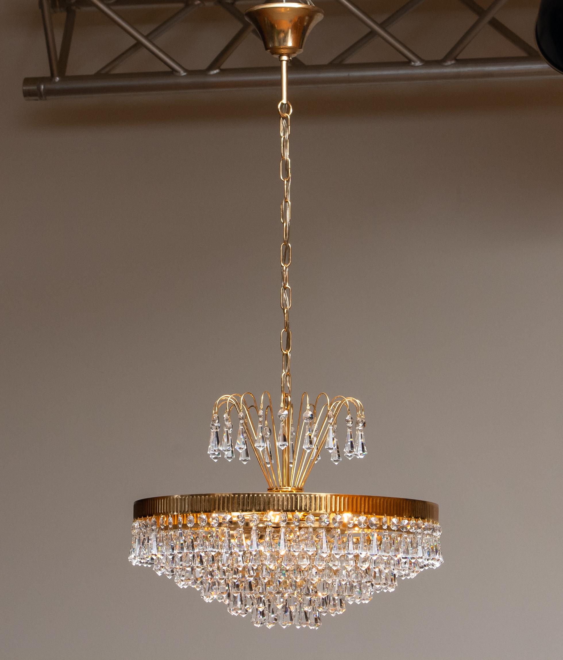 Extremely beautiful and rare 24-carat gold-plated chandelier made by Rejmyre Armaturfabrik Rejmyre, Sweden, 1960s.
The chandelier is build up out of six rings and a crown filled with faceted crystal chains, total diameter of the fixture is 40cm or