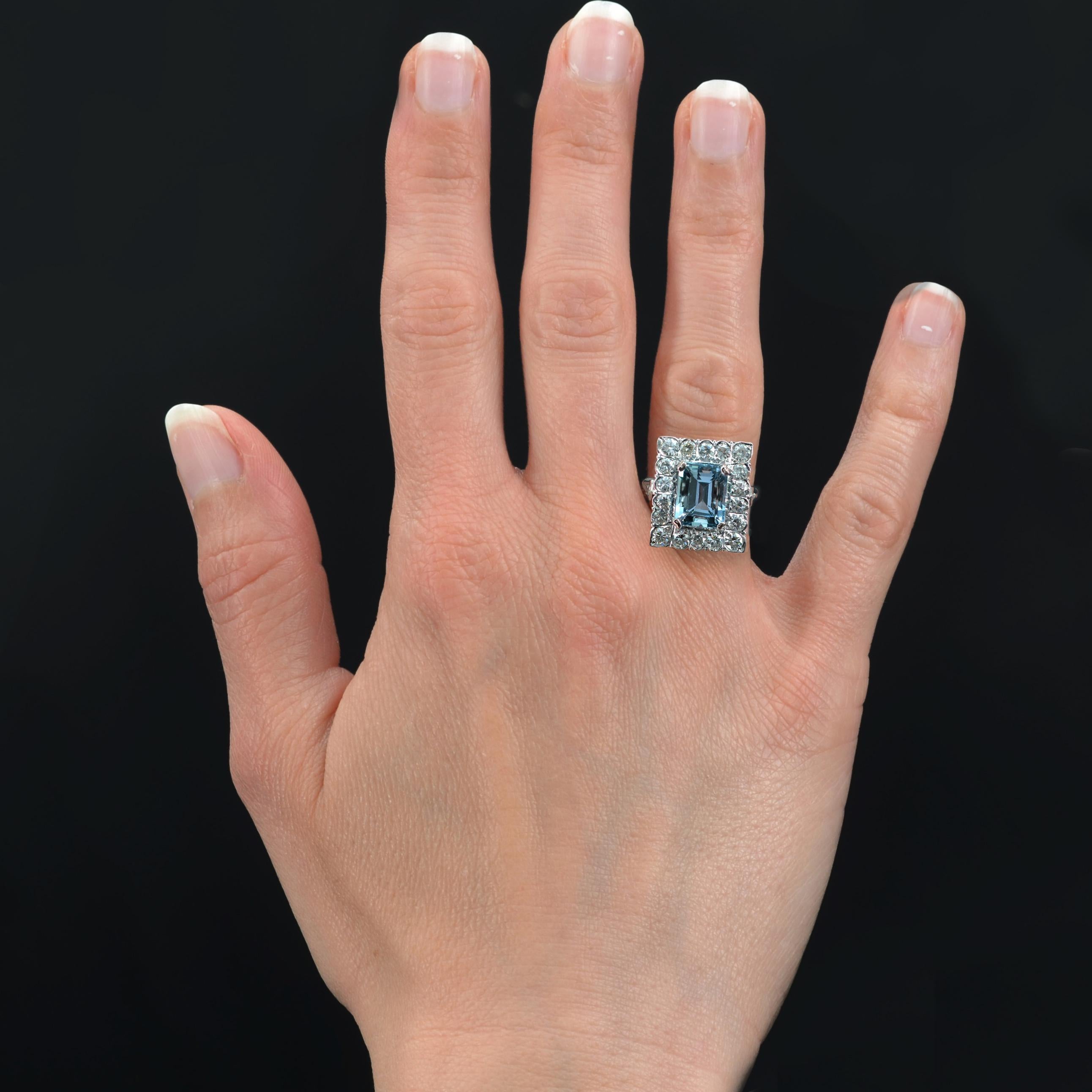 Ring in 18 karat white gold.
Sumptuous antique ring of rectangular shape, it presents in the center a degrees- cut aquamarine retained with 4 claws, in a surrounding of modern brilliant- cut diamonds. The flat basket is openworked at the back and