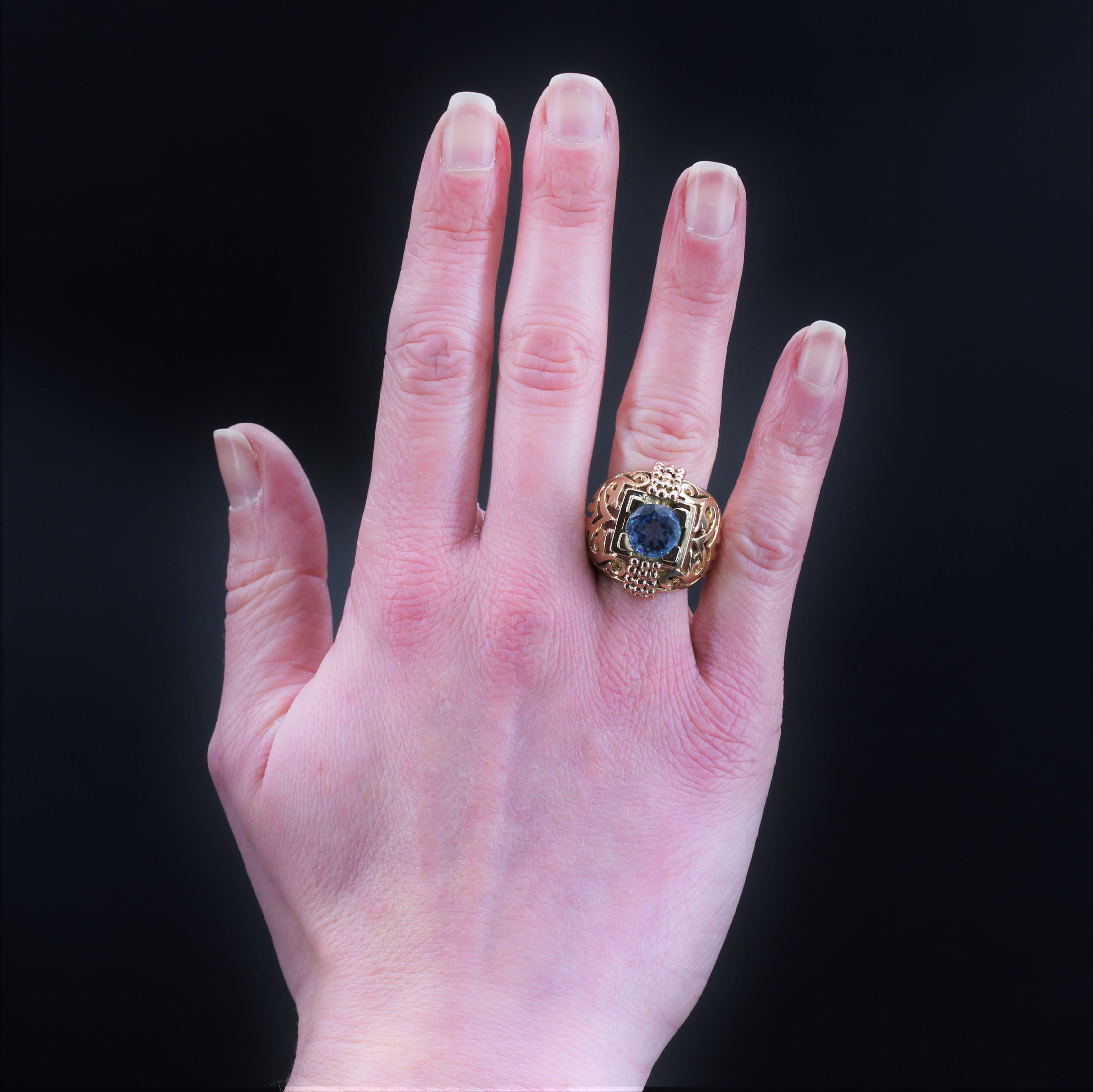 Ring in 18 karat yellow gold.
Dome ring, its setting is pierced with decorations in arabesques and lines on its two upper thirds. In the center, a geometrical setting holds a round faceted aquamarine of the most beautiful hue with 4 flat claws. Two