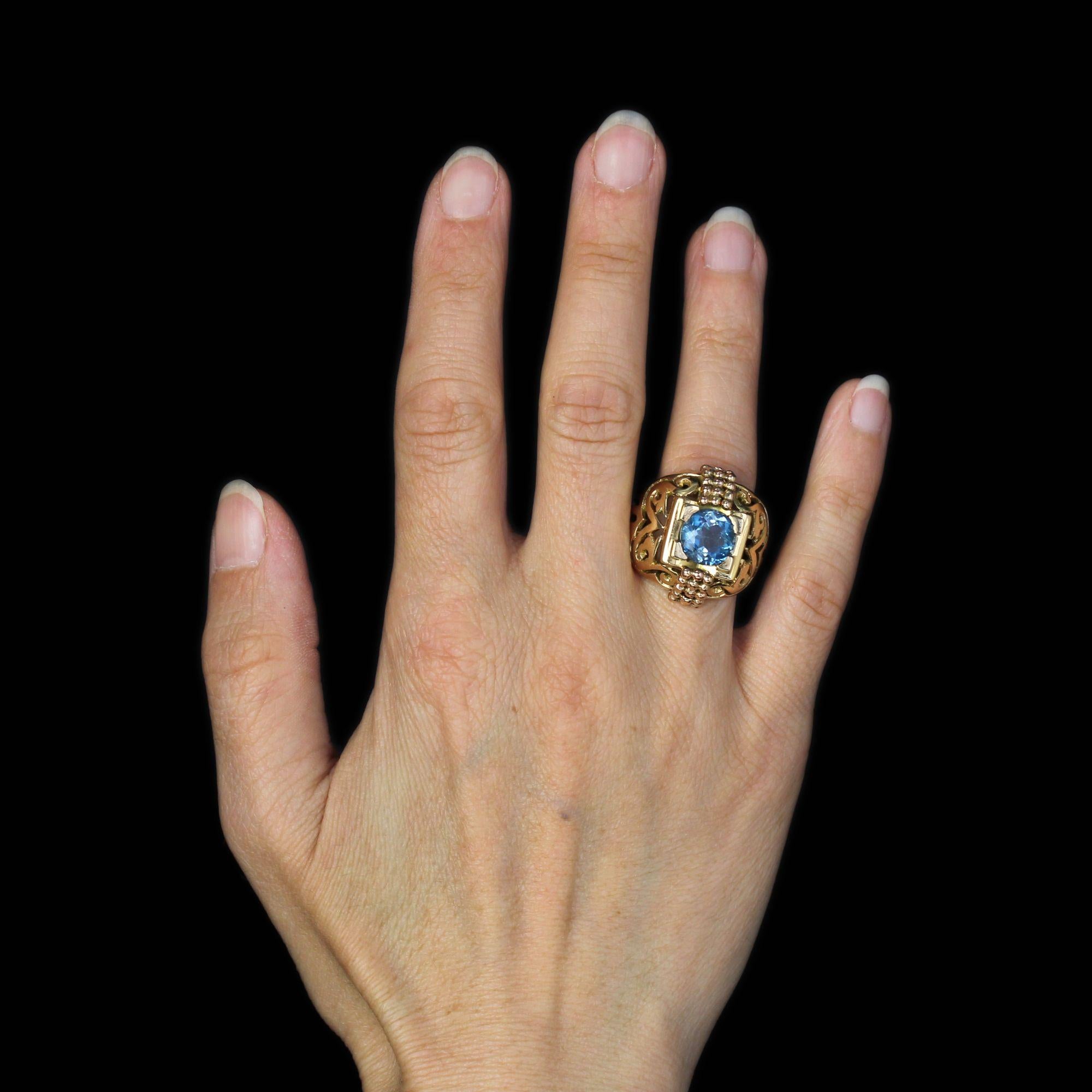 Bague en or jaune 18 carats.
Bague dôme, sa monture est percée de décorations en arabesques et lignes sur ses deux tiers supérieurs. Au centre, une monture géométrique retient une aigue-marine ronde facettée de la plus belle teinte avec 4 griffes