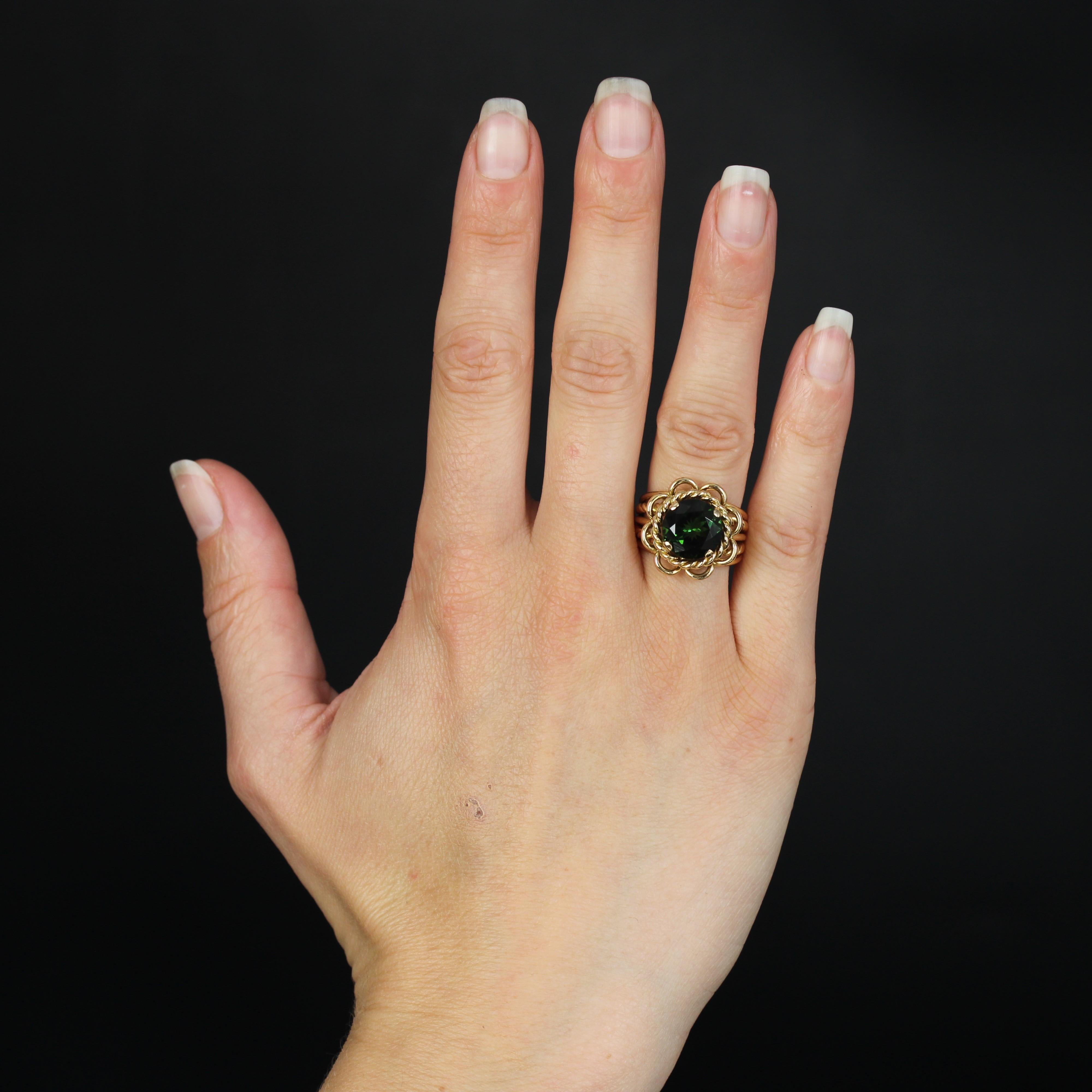 Ring in 18 karat yellow gold.
The original setting of this vintage ring is made of gold wire and gold cords that form the band and the basket that supports a large round faceted green tourmaline held in place by 4 claws.
Total weight of the
