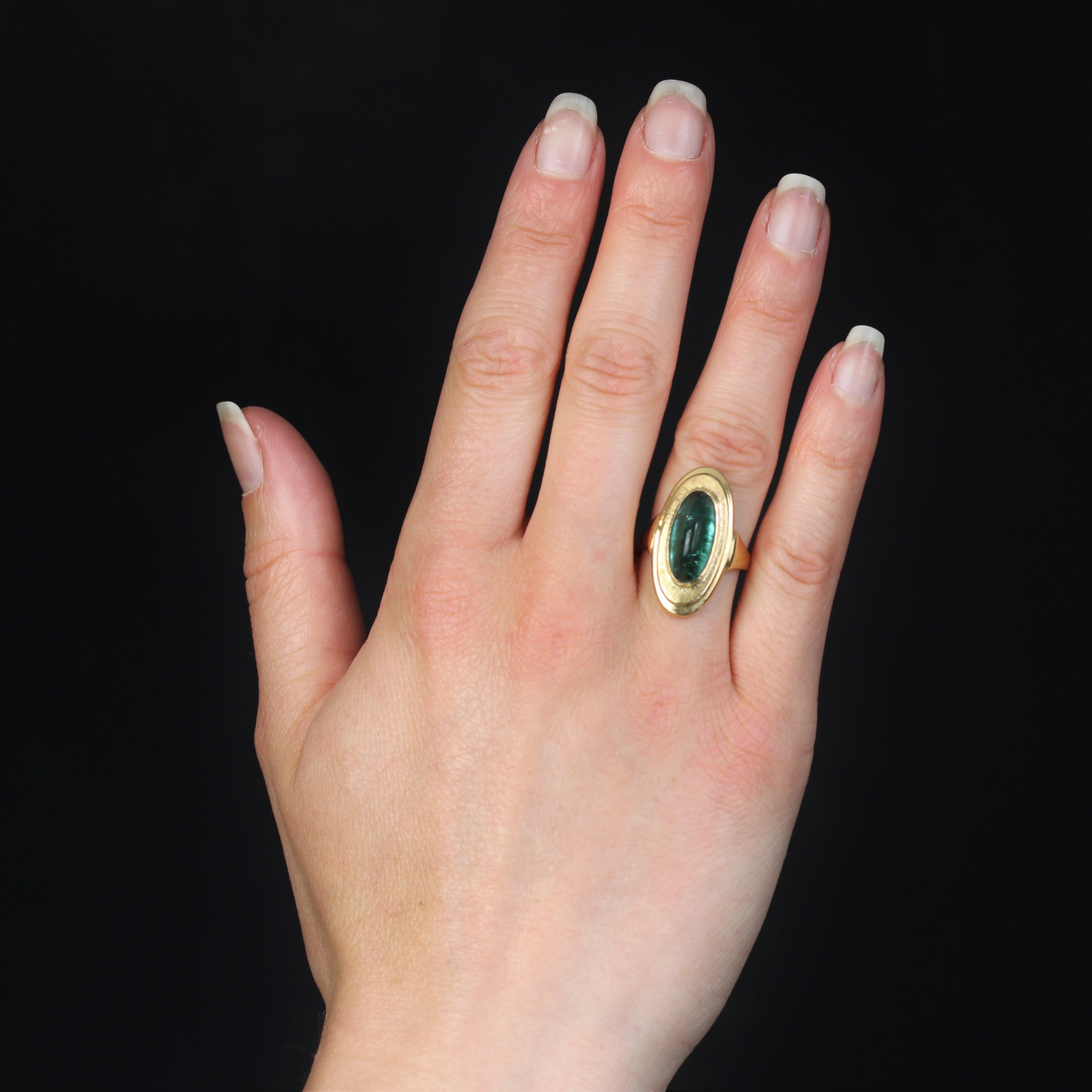 Ring in 18 karat yellow gold.
This slender, oval-shaped vintage ring in yellow gold features a central sugarloaf cut green tourmaline. The surround is chased. The departures of the ring are fan-shaped and drop-shaped.
Total tourmaline weight : 4.60