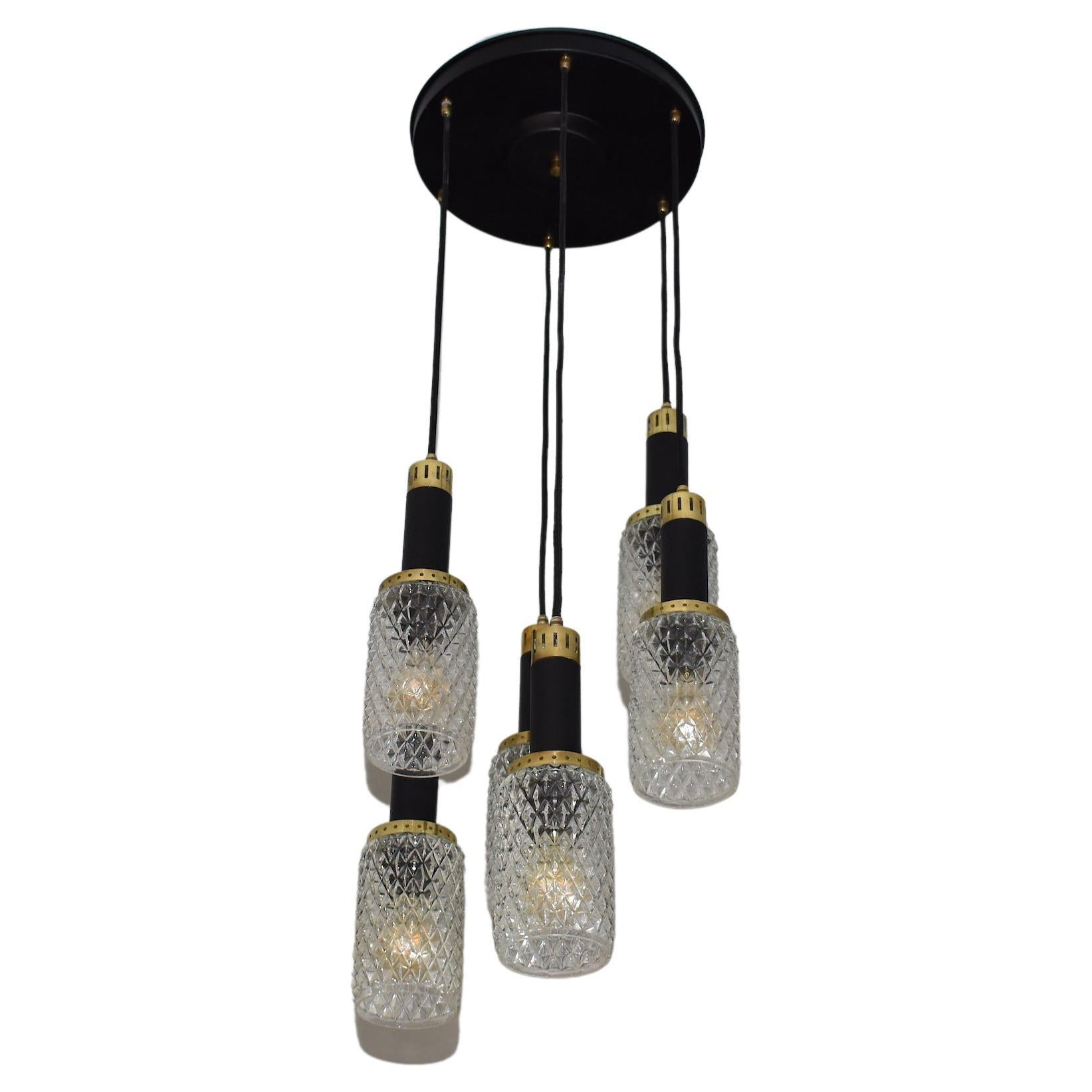 Un fantastico pendente a 6 luci vintage italiano del Mid-Century Modern di Stilnovo. I paralumi sono realizzati in vetro testurizzato di alta qualità e sono evidenziati da dettagli in alluminio nero e ottone dorato lucido. 
Italia. Circa anni '50.