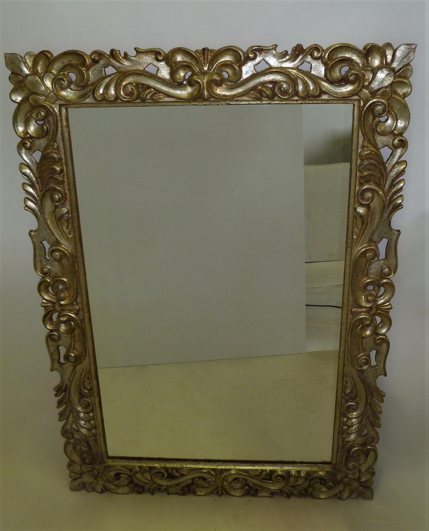 Created in either 1969 or 1970, this silver gilt Florentine style mirror is impressive and very elegant. Carved wood, probably Italian, the mirror glass is American, produced by Gardner Glass in North Wilksboro, North Carolina (marked on the reverse