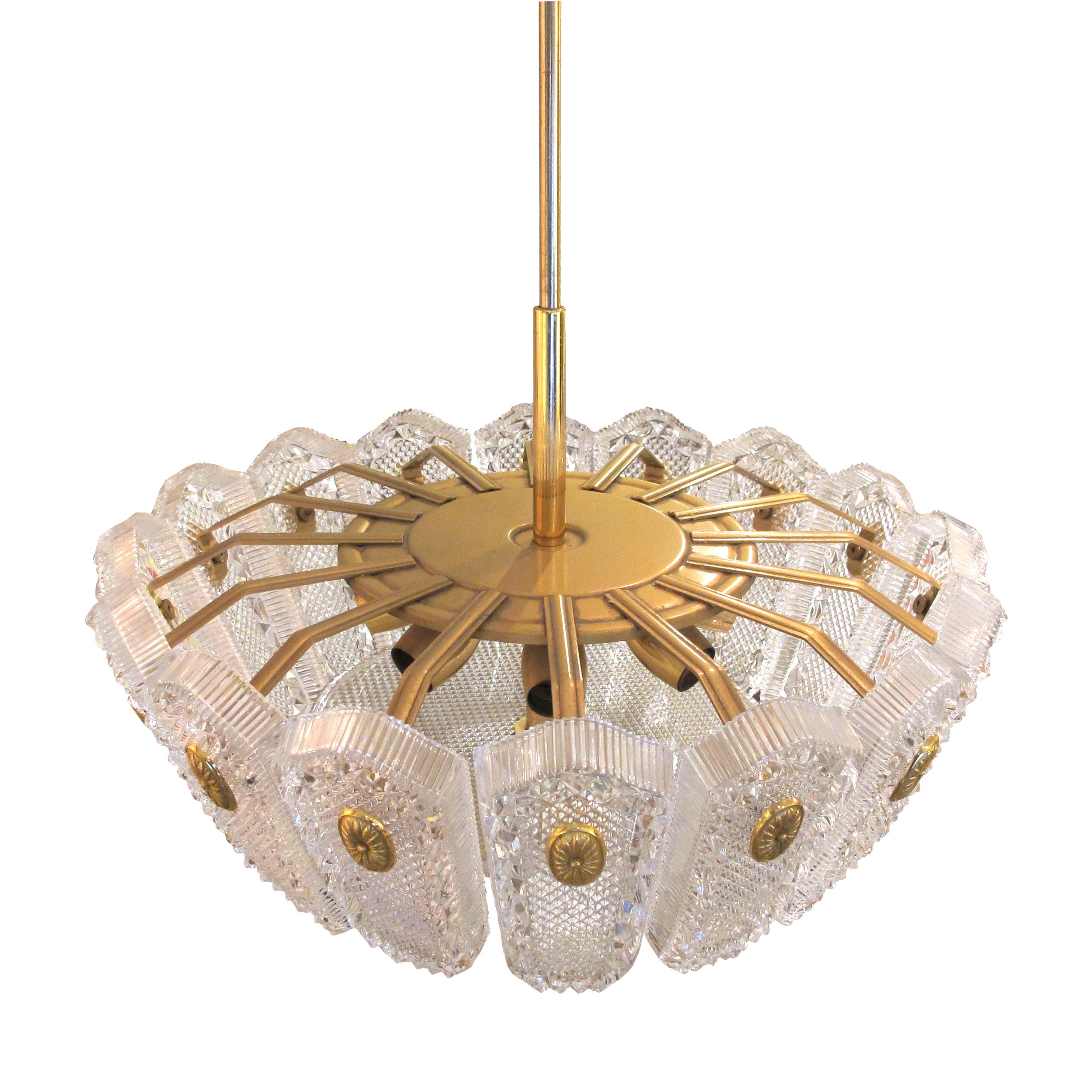 The ceiling light is a large light made with a series of 16 beautifully decorated glass panes held onto the frame by brass medallions. The chandelier is a great example of Orrefors's work in the 1960s/70s. During this period, the company was known