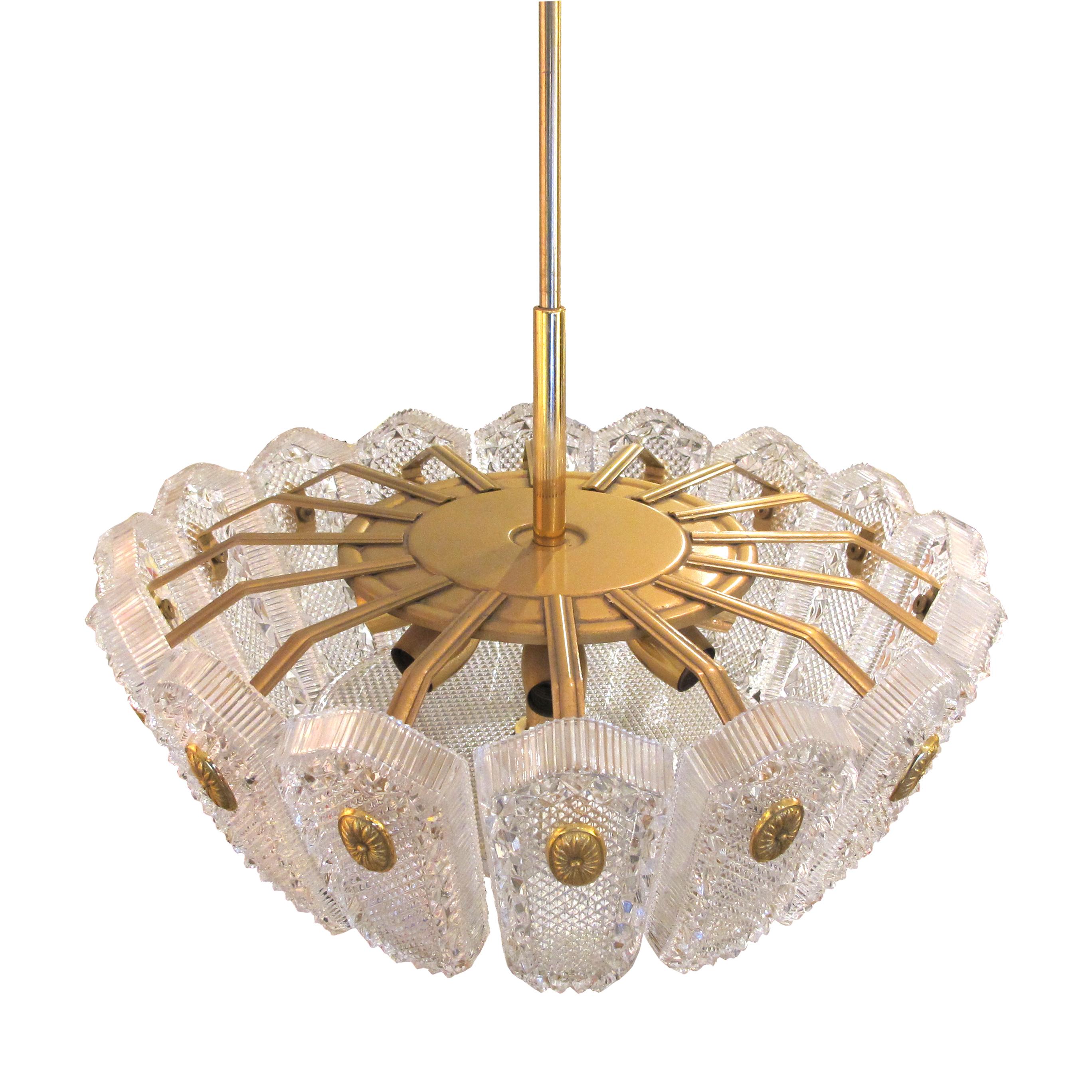 La plafoniera è una luce di grandi dimensioni realizzata con una serie di 16 lastre di vetro splendidamente decorate, fissate alla struttura da medaglioni in ottone. Il lampadario è un ottimo esempio del lavoro di Orrefors negli anni '60/70. Durante