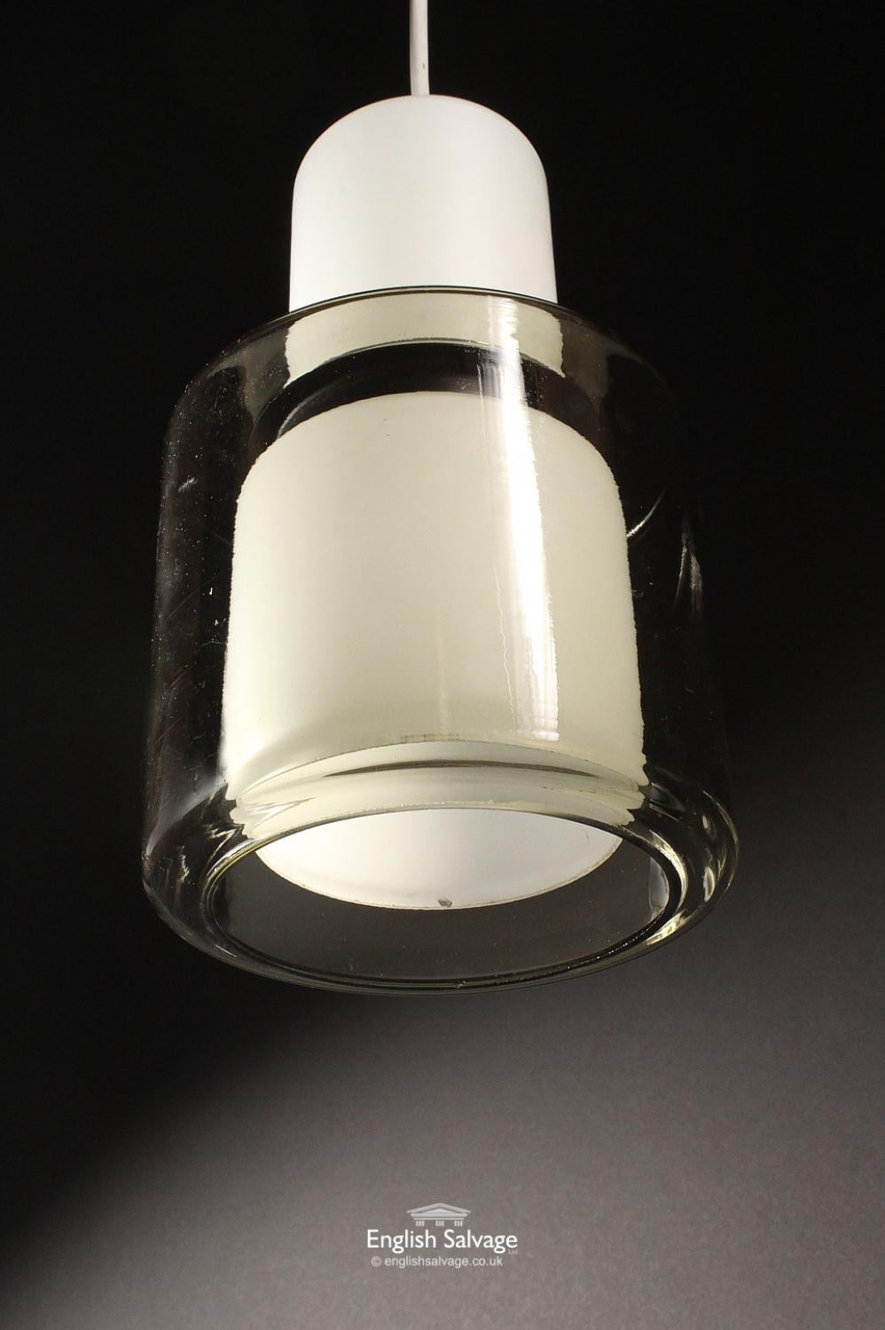 A large set of salvaged vintage 1960s/1970s smoked glass ceiling lamps would add a certain retro style to a discerning pub or restaurant. The light consists of a white glass interior seated in a smoked glass surround. The diameter of the smoked