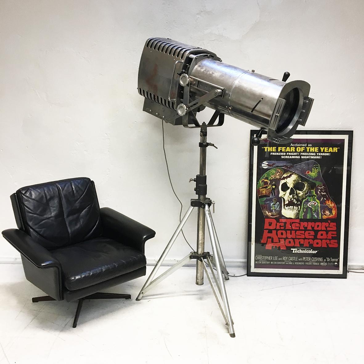Originally an electric ‘following spot’ stage light model 755 made by the Strand company. This fantastic tripod lamp has at some point been converted to a home interior feature lighting piece. The substantial pressed steel body on stand, has been