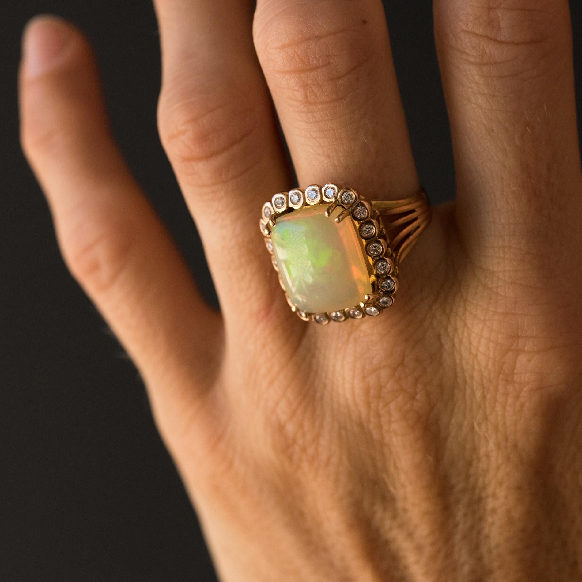 Ring in 18k rose gold.
The centrepiece, a double claw set rectangular opal cabochon, is surrounded by 22 brilliant cut diamonds. The head of the ring is perforated and the shoulders are formed of 4 golden threads that come together to form the base.