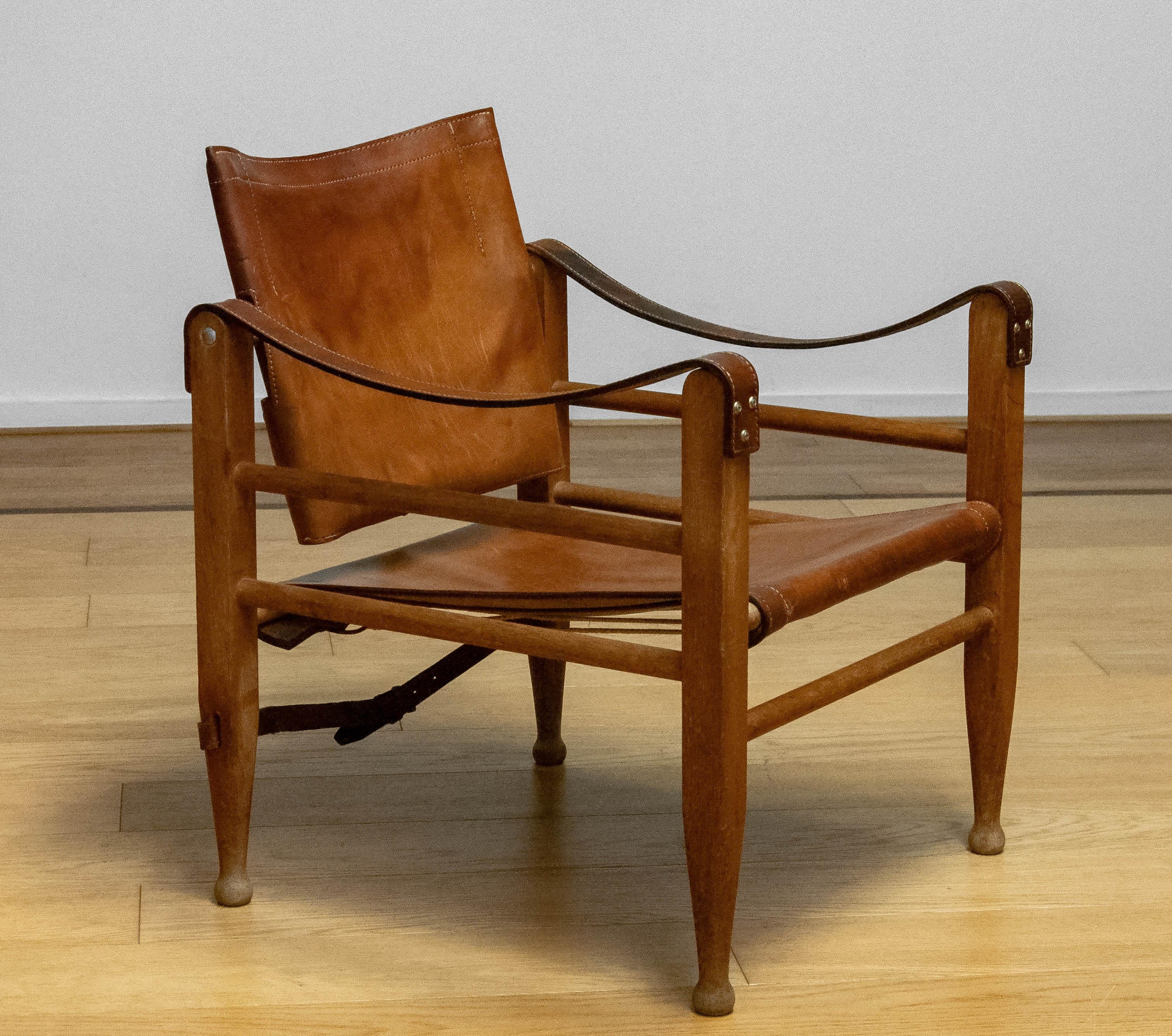 Beautiful safari chair designed by Aage Bruun & Son in Denmark in the 1960s. 
The chair has a wooden frame with cognac leather armrests, seat and backrest. 
The chair is glued and therefore cannot be taken apart. 
Belt repaired between the rear legs