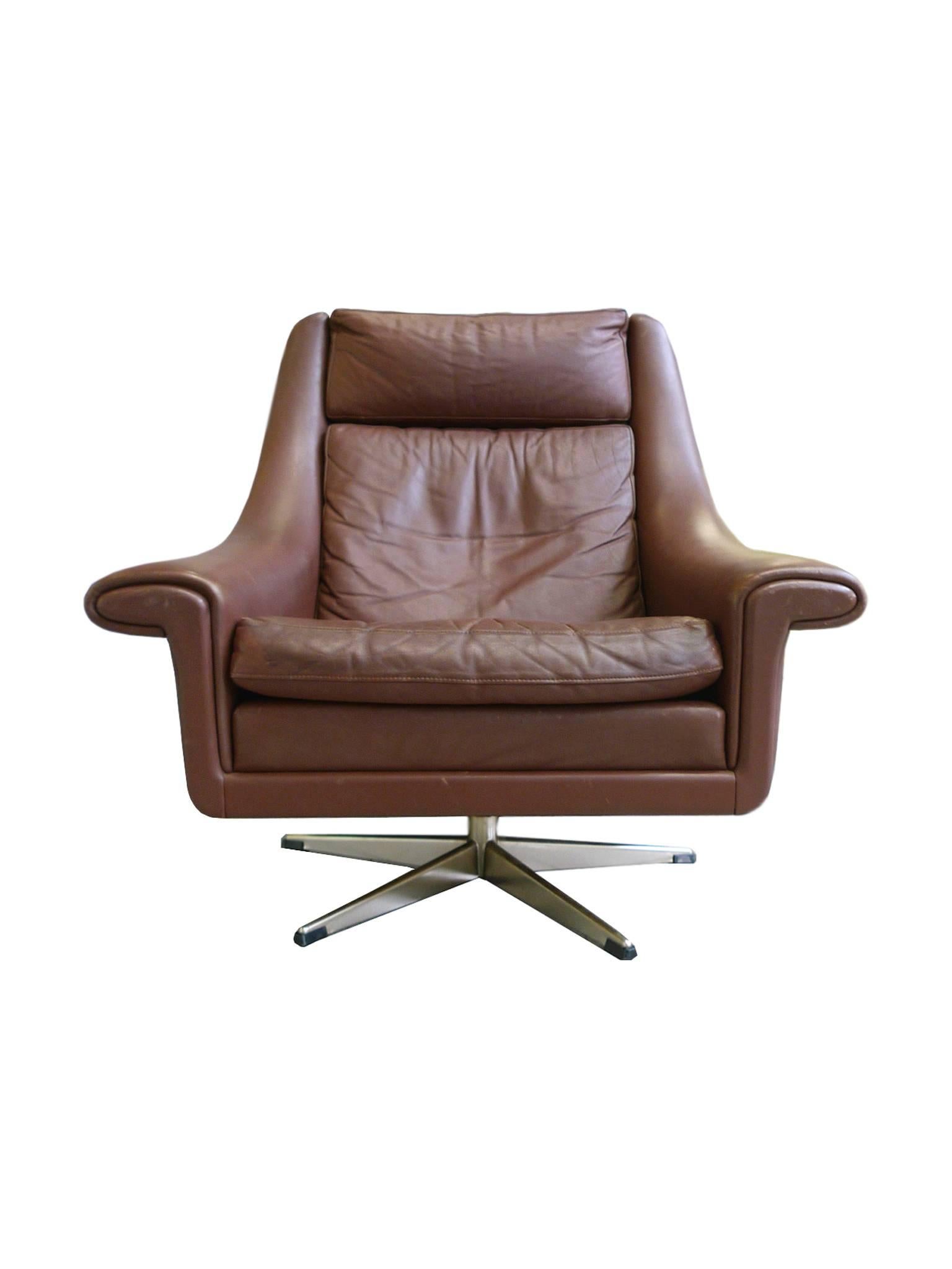 This is the Ambassador chair designed by Aage Christensen in the 1960s and manufactured by Erhardsen & Andersen in Denmark. The chair's design is one of openness and embrace, a perfect lounge chair with a high back and wide seating. The upholstery