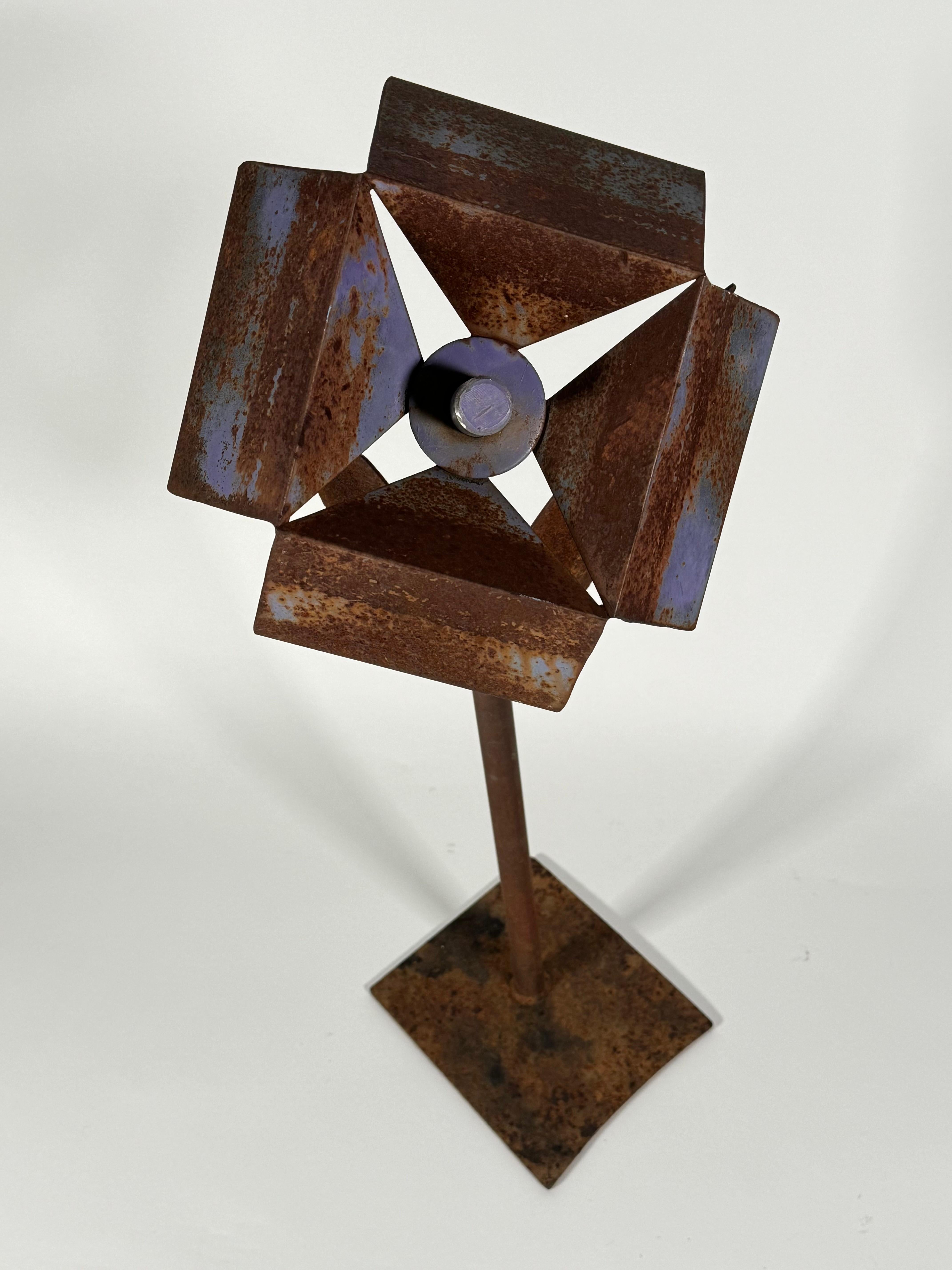 Abstract welded metal sculpture of a flower by an unknown artist, having a nice patina from being left out in the elements from over the years. There is an hint of paint on the petals. A striking blend of both rustic and modernist aesthetics.