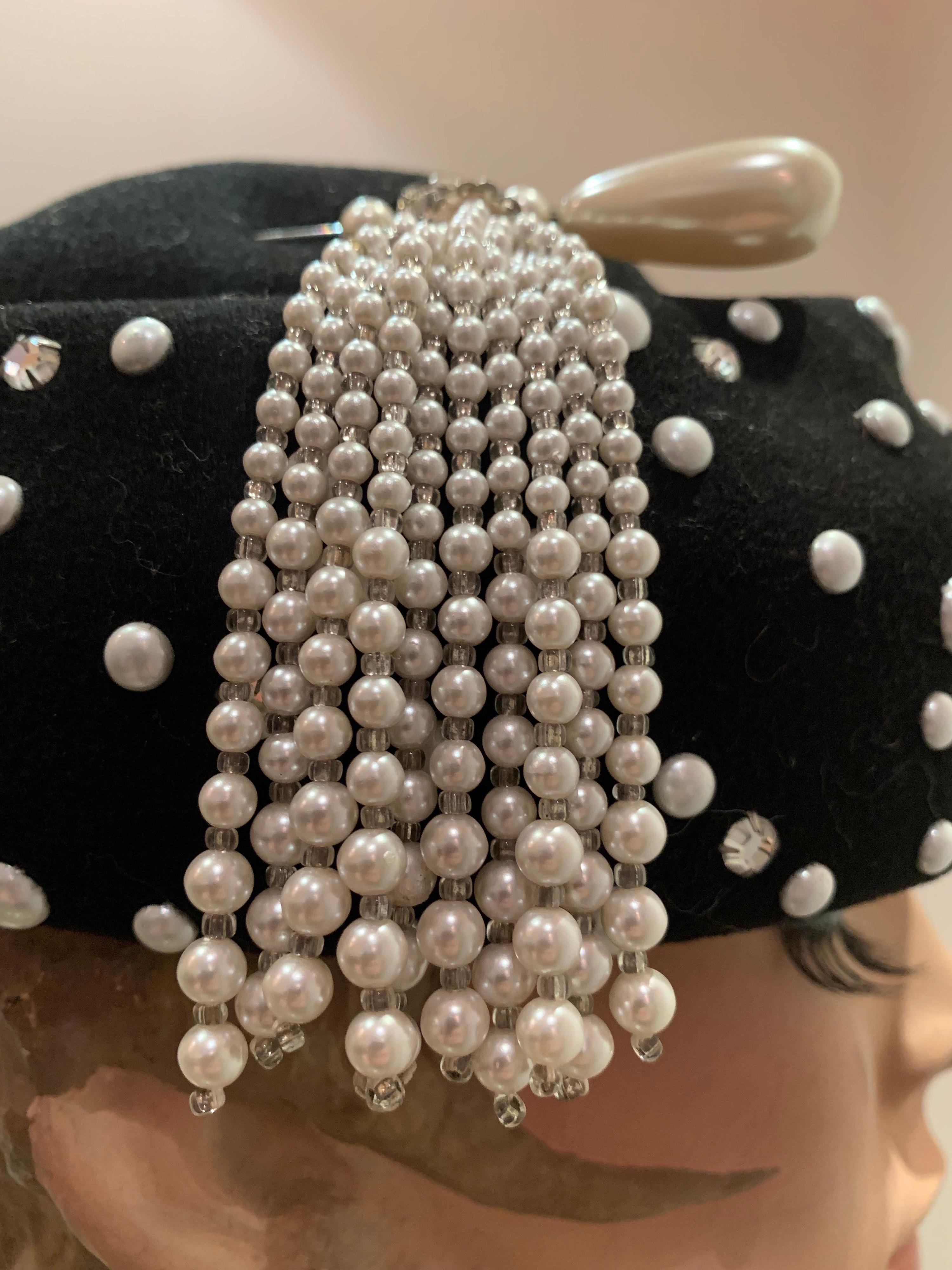 A 1960s Adolfo II black wool felt molded hat studded with faux pearls and rhinestones.  Original matching pearl tasseled hat pin included.