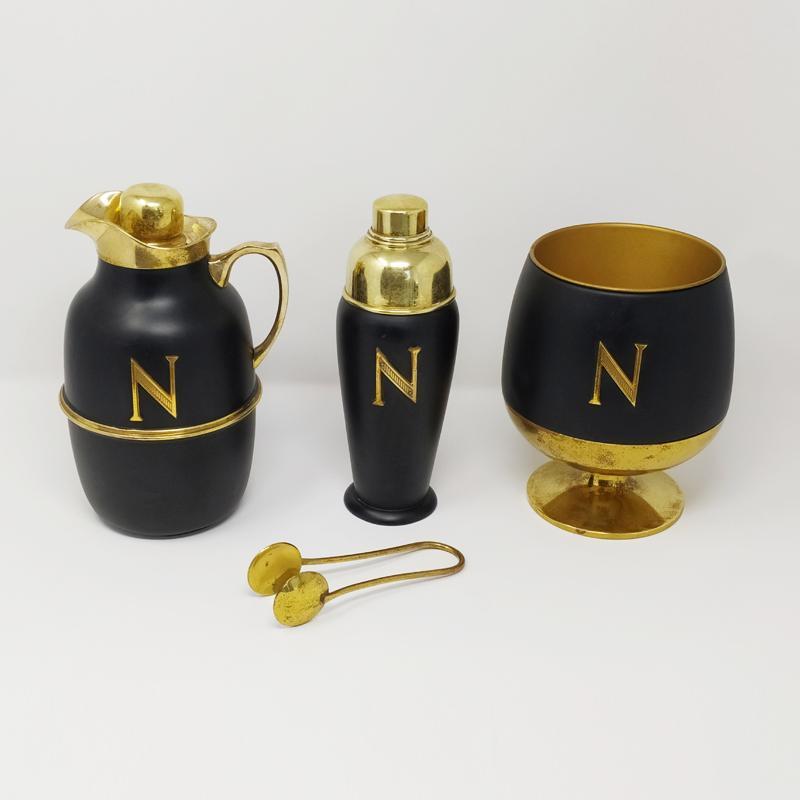 This original astonishing cocktail set in brass and black lacquered brass was designed by Aldo Tura Macabo for Napoleon Cognac and produced in Italy by Cusano Milanino. The set includes a thermos, a cocktail shaker and an ice bucket with pliers.