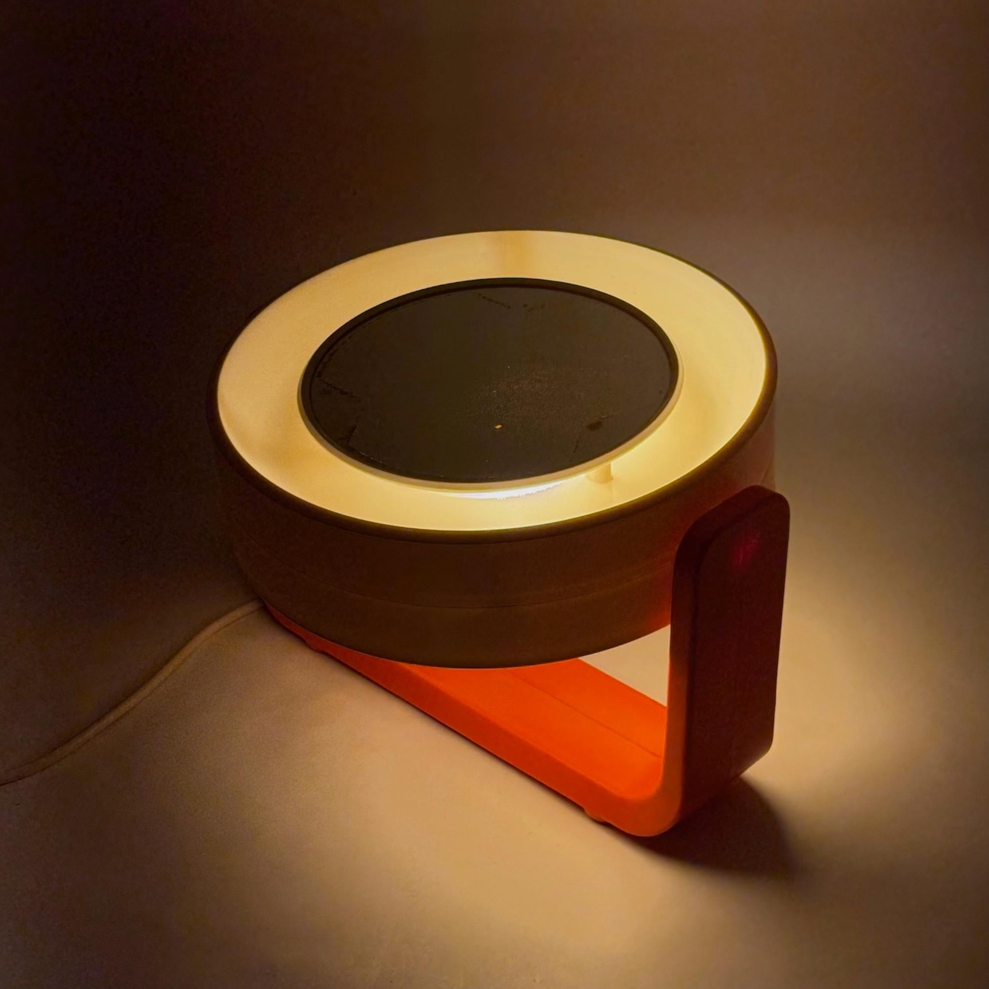 An original 1960s illuminated mirror designed by Allibert, exemplifying the playful functionality of Space Age design. This striking vanity accessory is built with a bold orange plastic base and features an integrated lighting system that highlights