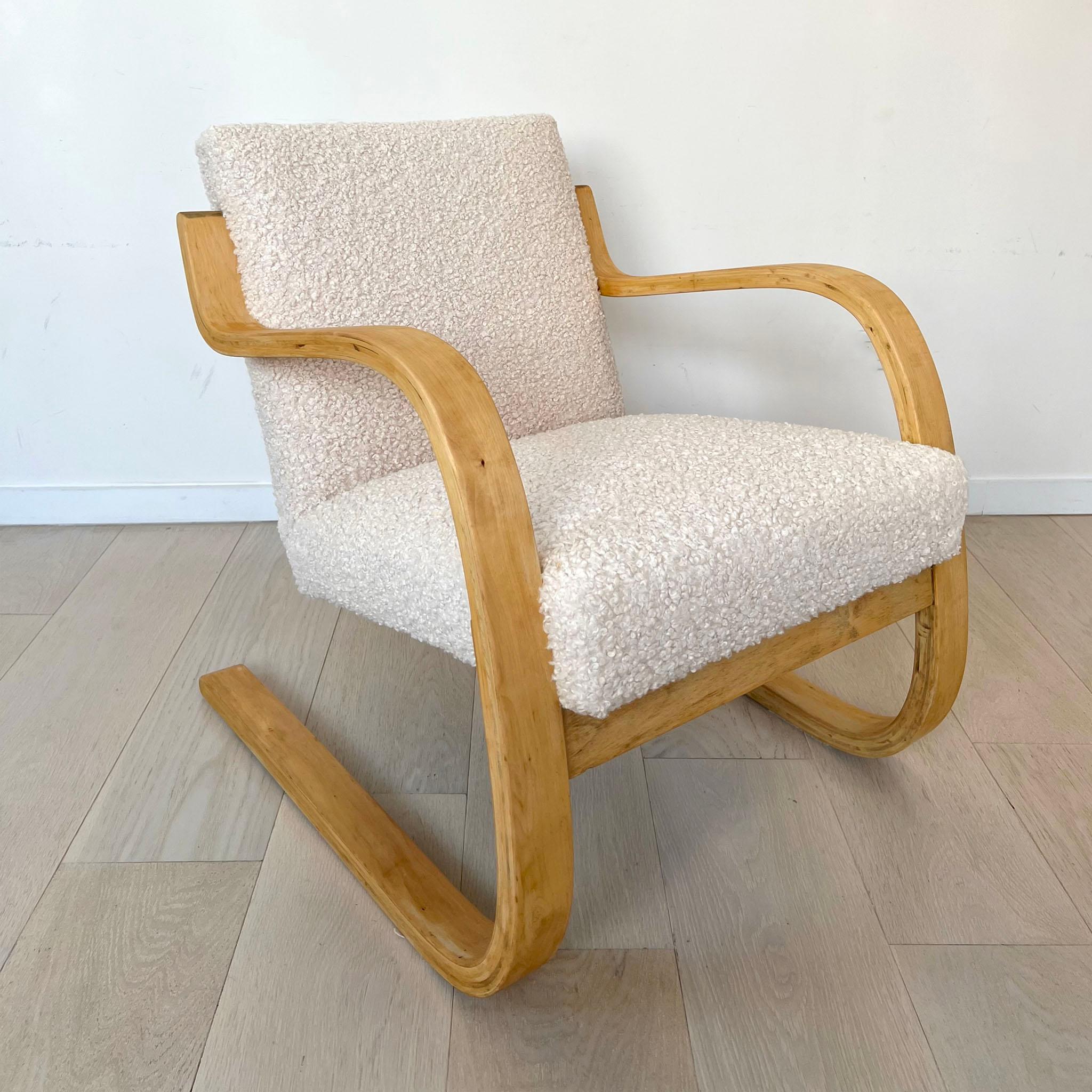 Alvar Aalto armchair model 403, designed originally in 1933. Aalto was an innovative designer who experimented with bentwood. The birch frame consists of layers of plywood which flex allowing for sitting comfort. The seat and backrest have been