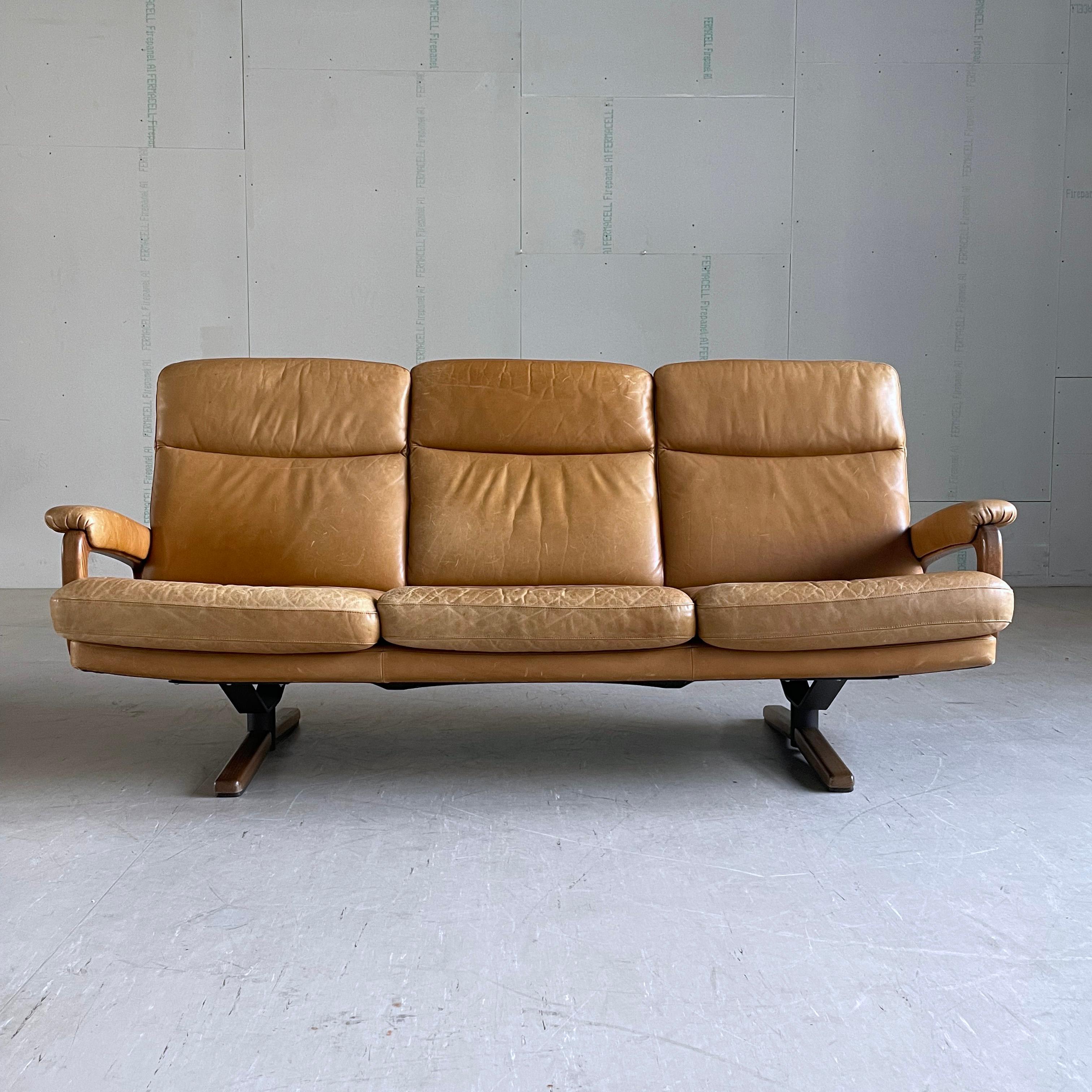 3-Sitzer-Sofa aus den 1960er Jahren aus hochwertigem gegerbtem Leder. Entworfen von André Vandenbeuck und hergestellt von Strässle, Schweiz. 
Das Leder ist in einem sehr guten Allgemeinzustand mit normalen Gebrauchsspuren wie Schrammen und leichten