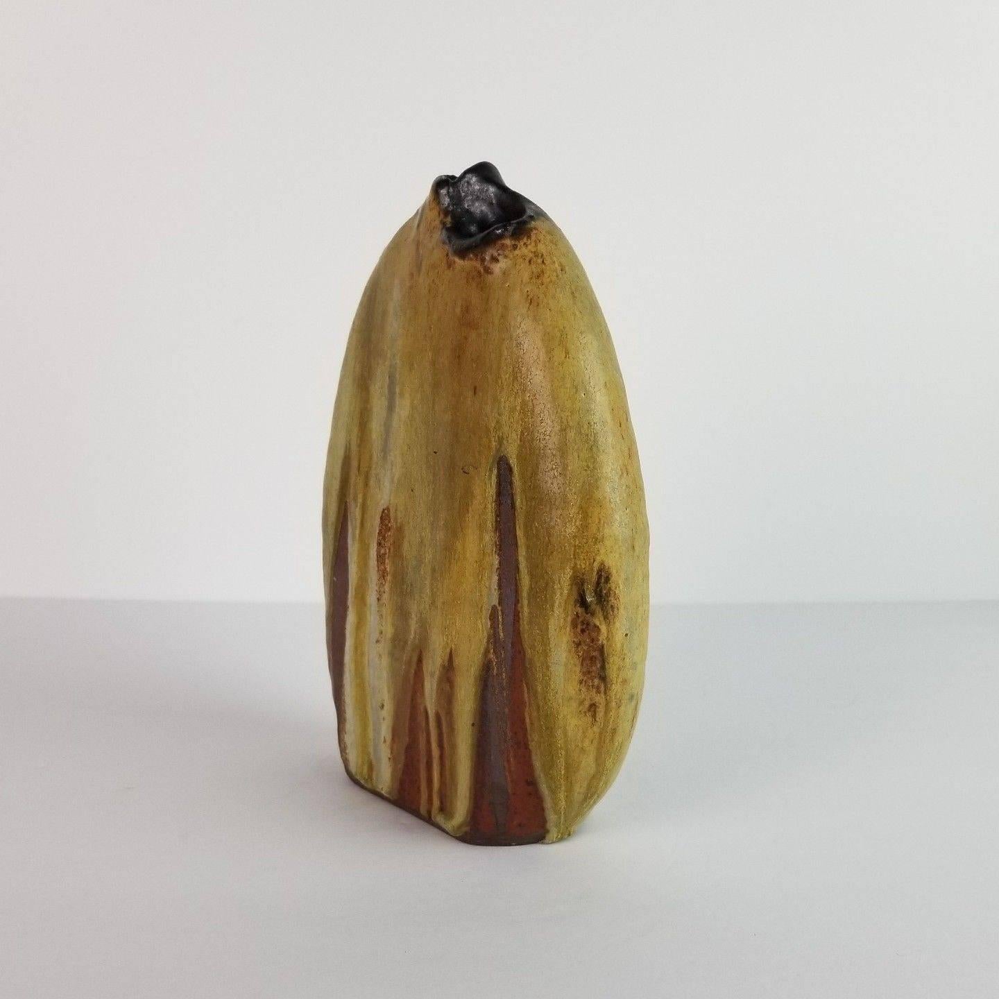 1960s abstract expressionist vase by California potter Andrew Bergloff. Vase has two spouts, one on each side, and one main compartment.
Lovely thick drip glaze in earth tones of cream, brown, and rust orange. A heavy and substantial piece, in