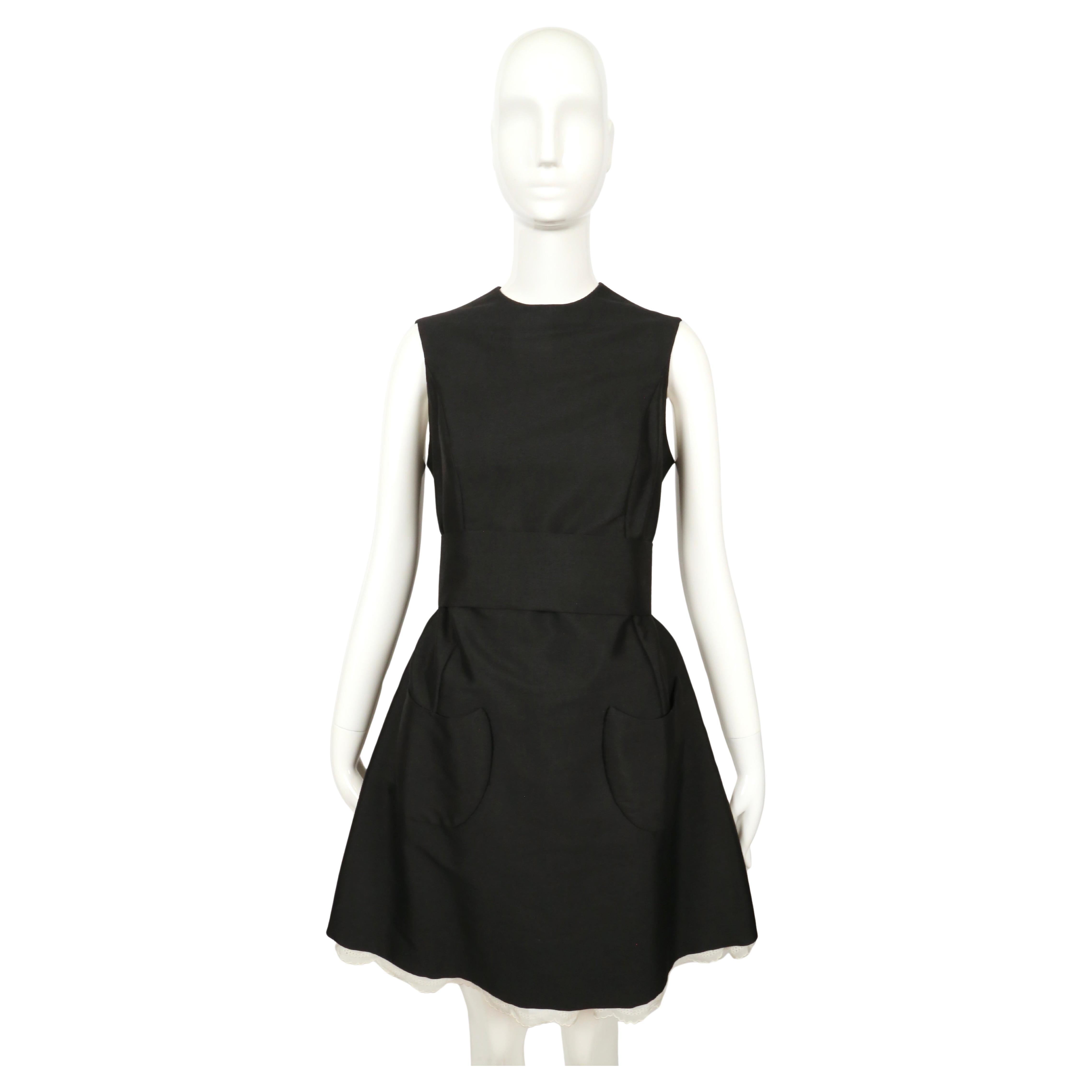 Jet black haute couture dress with Broderie anglaise lace trim and uniquely shaped patch pockets designed by Antonio del Castillo dating to the 1960's. Hand finished throughout. Best fits a US 4-6. Approximate measurements: shoulders 14.5