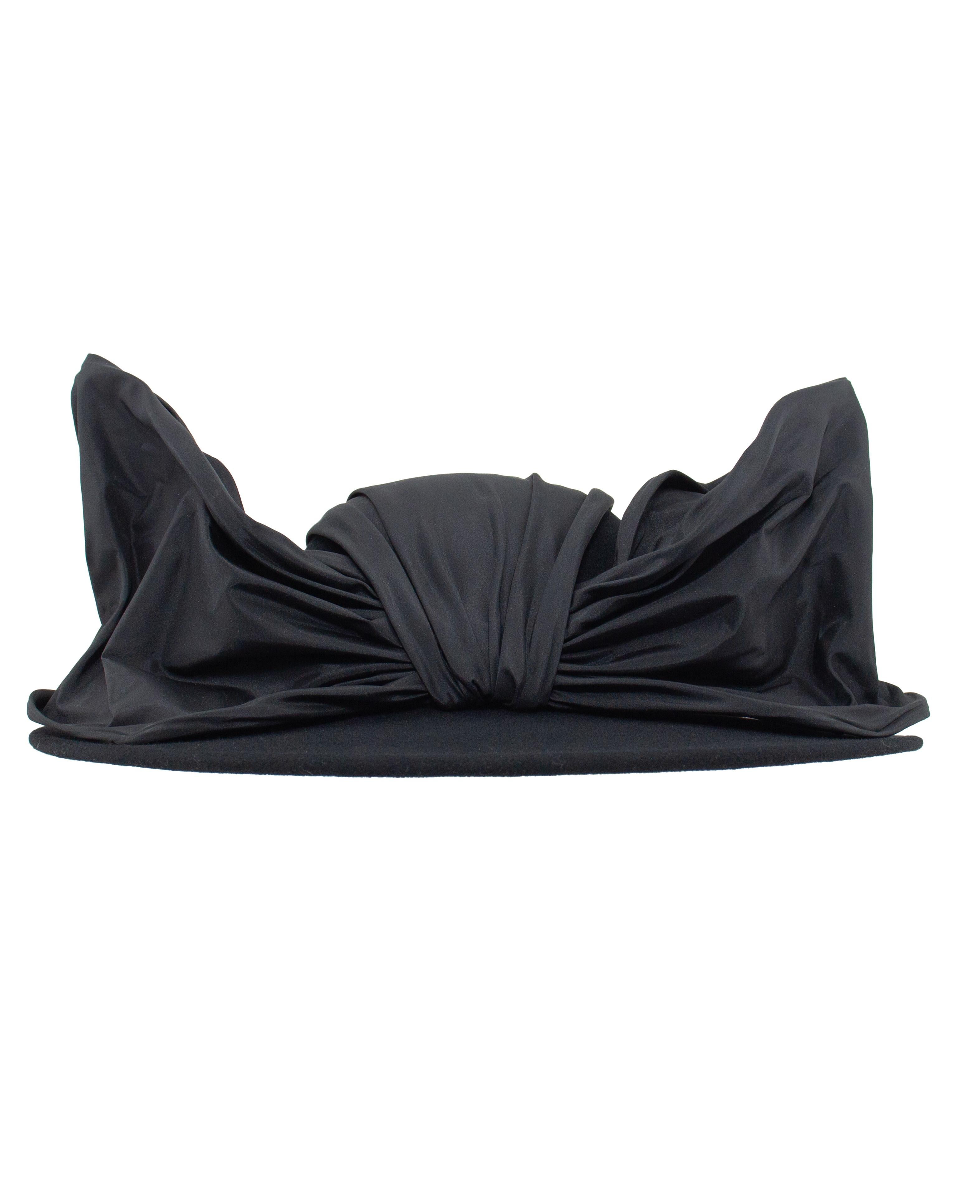 Drammatico cappello vintage di Archie Eason, un maestro modista famoso per il suo approccio scultoreo ai copricapi femminili. Realizzato negli Stati Uniti in feltro di lana al 100% da Excello, questo pezzo di metà secolo è un mix sorprendente di