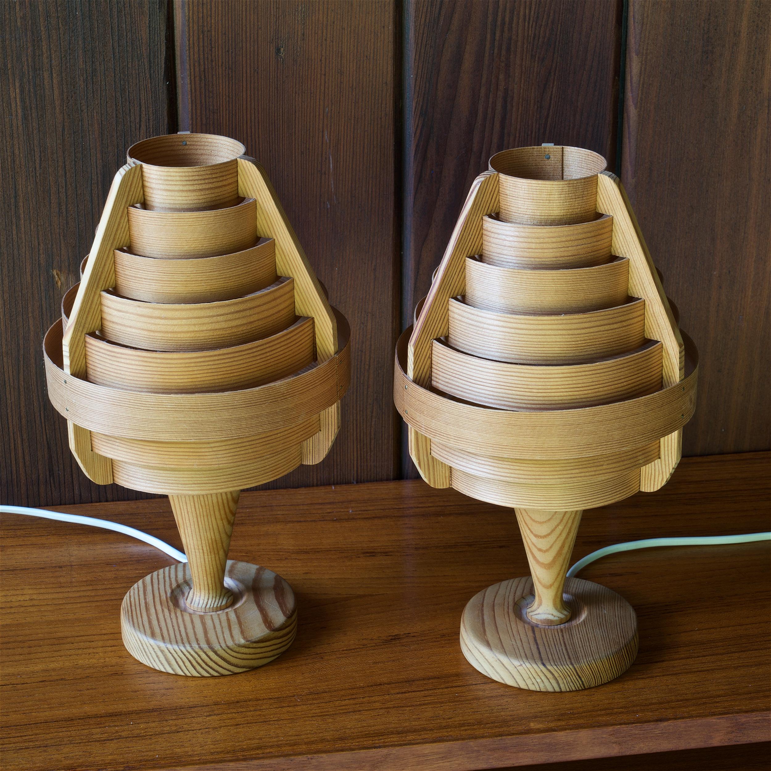 A pair of 1960s wooden bedroom table lamps designed and produced by Hans-Agne Jakobsson for AB Ellysett, Markaryd, Sweden. Executed in fine pine strips and turned pine bases. Very delicate organic architectural lamp series. The thin wood acts as a
