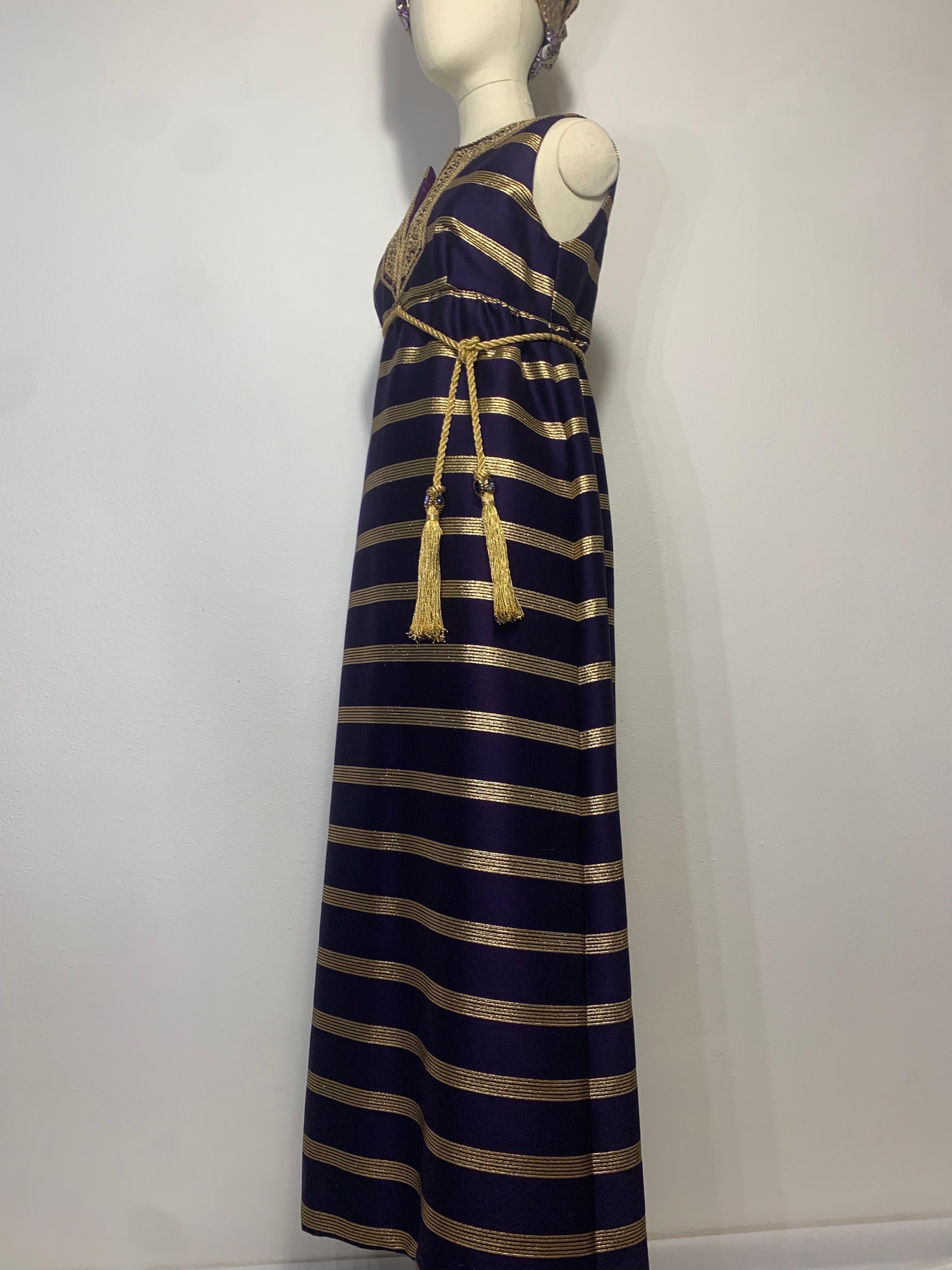 1960s Arkay Purple & Gold Lame Sharkskin Moroccan Inspired Embroidered Maxi: Empire waist height gold cord belt with tassels attached. Broad horizontal gold lame stripe strike a bold figure and a delicately embroidered gold neckline with prong-set