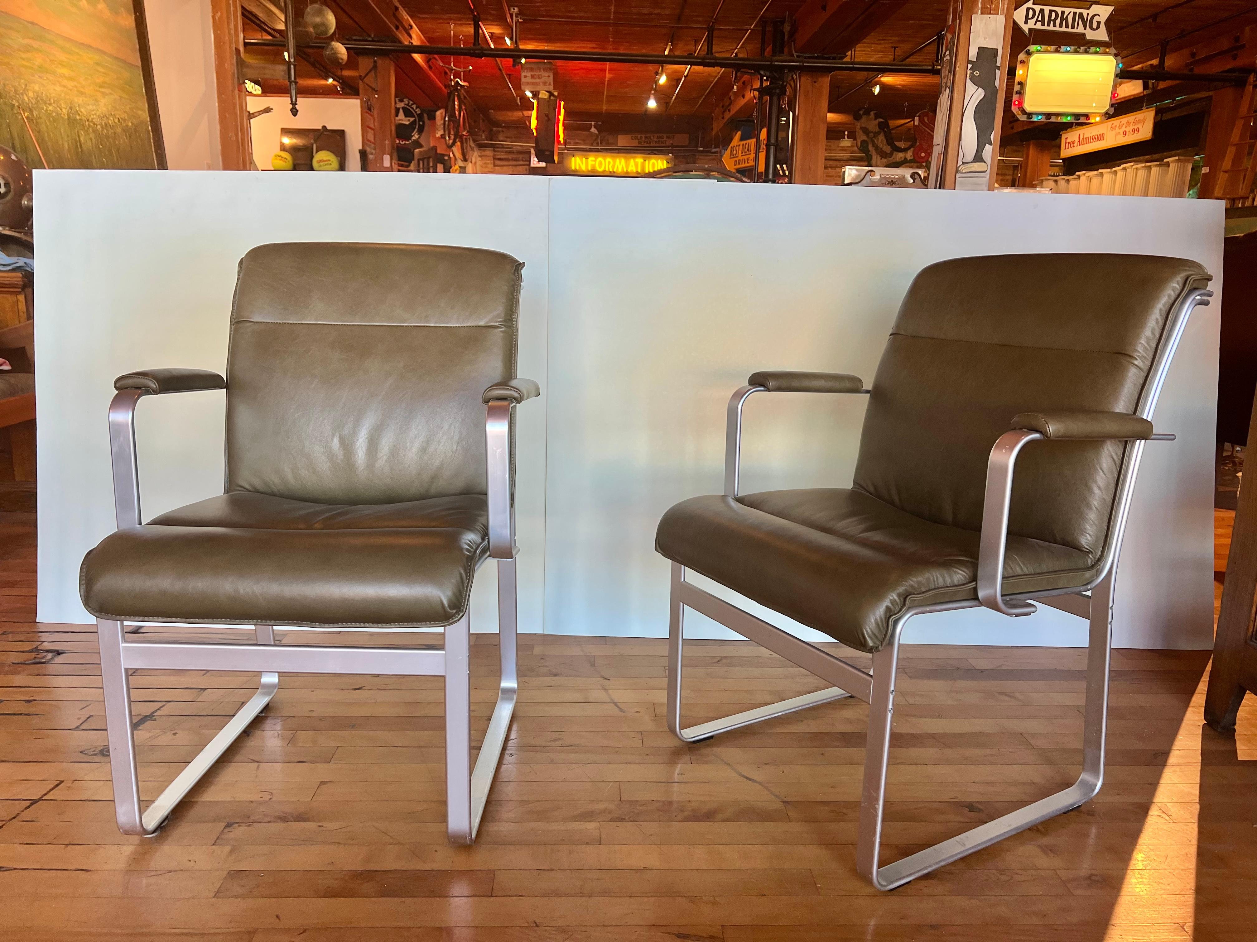 1960’s side armchairs with aluminum base and new leather upholstery. Designed by Karl Erik Ekselius. Arm height 26”.