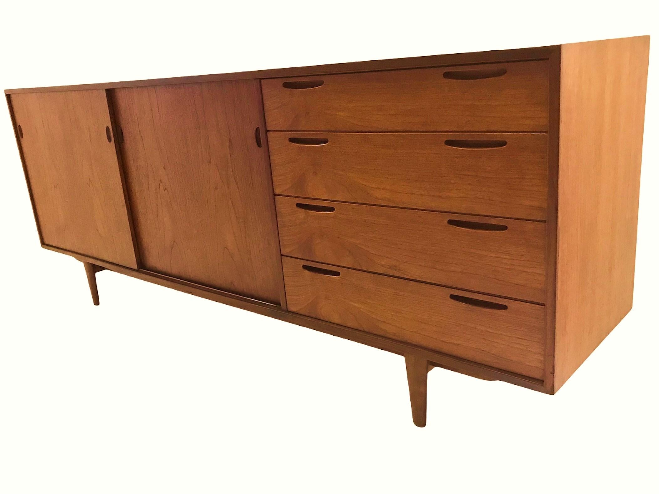 Fine Danish teak credenza by Arne Hovmand-Olsen for Selig. Featuring beautifully figured teak, it has sliding doors to the left opening to an adjustable shelf and two half drawers. To the right, four drawers with inset pulls. Great storage and