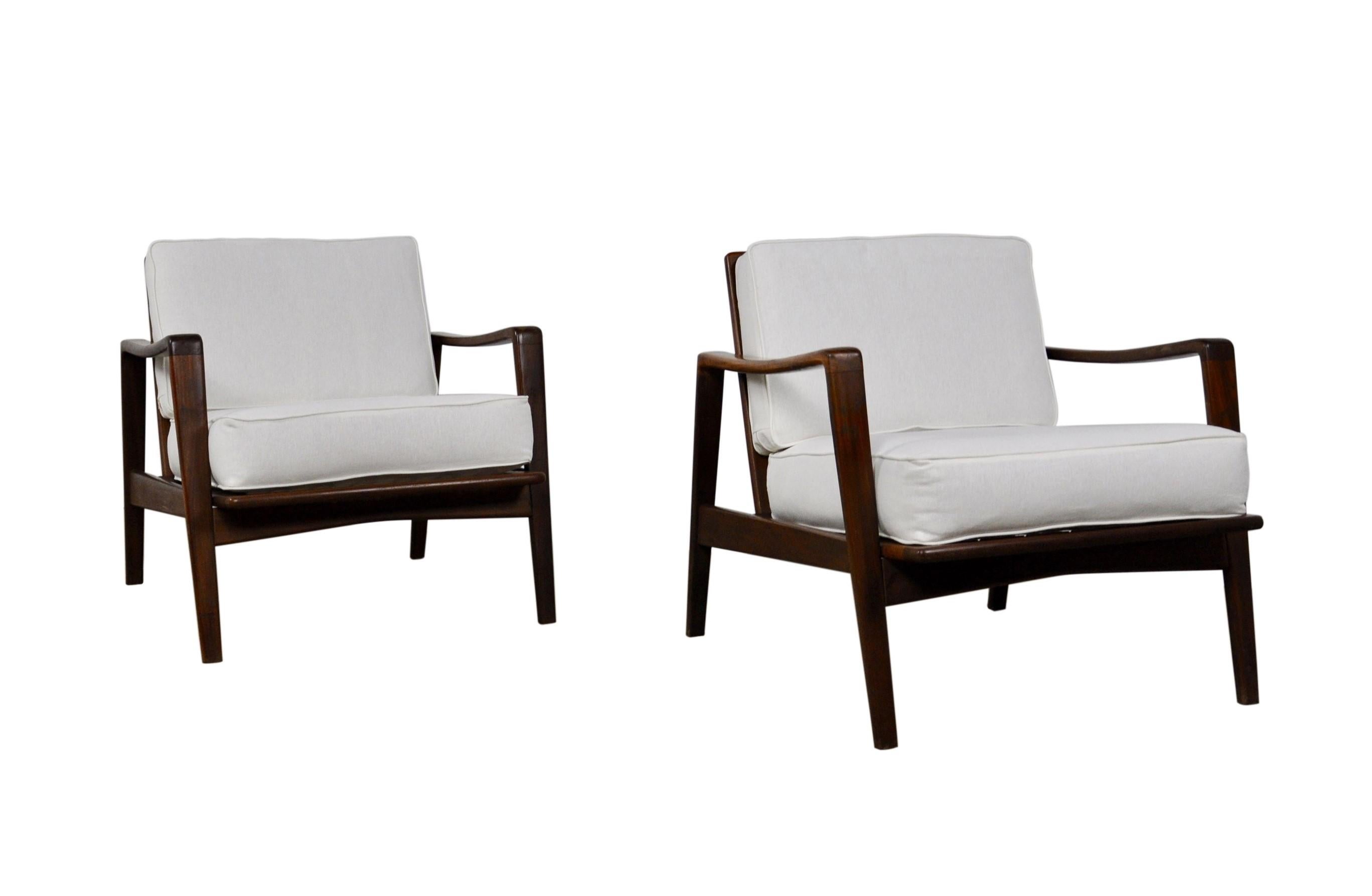 Pair of easy chairs model no. 30 designed by Arne Wahl Iversen, manufactured by Komfort, Denmark, 1960. These comfortable chairs have solid teak wooden frames and white upholstered cushions. Sculptural modern teak frames can be displayed at any