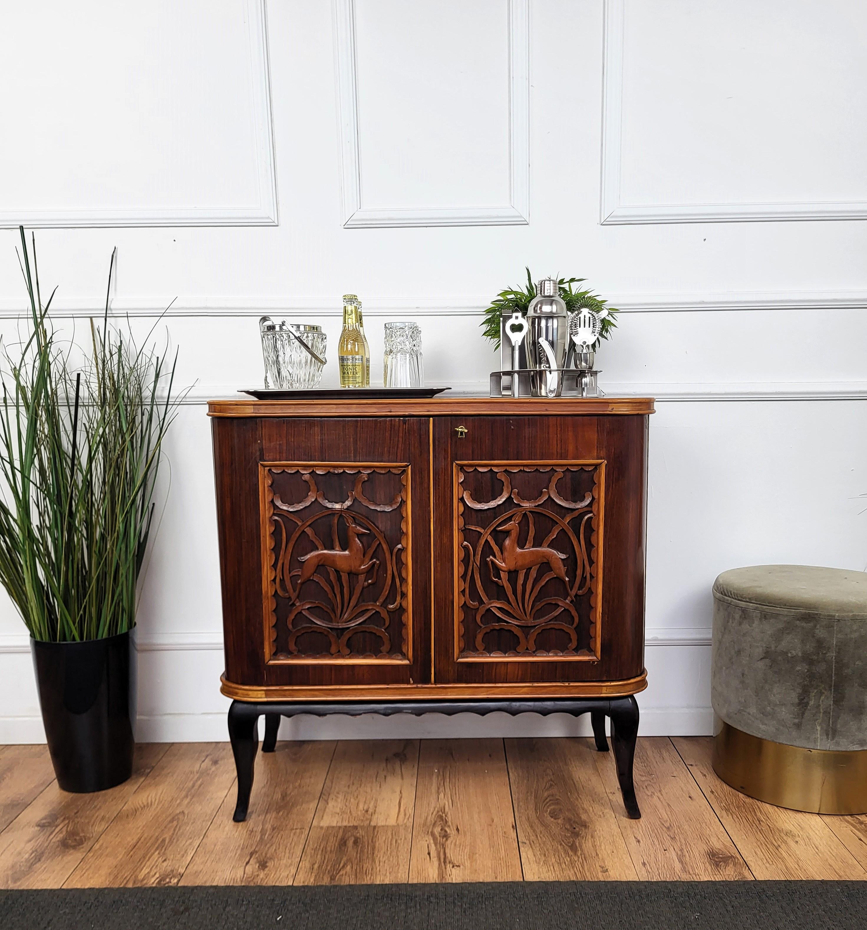 Unique and very elegant Italian Art Deco Mid-Century dry bar cabinet, in walnut with double front door having amazing interior part with mirrors and a two-tier side bottle holders. The piece is highlighted by the typical frontal wildlife forest
