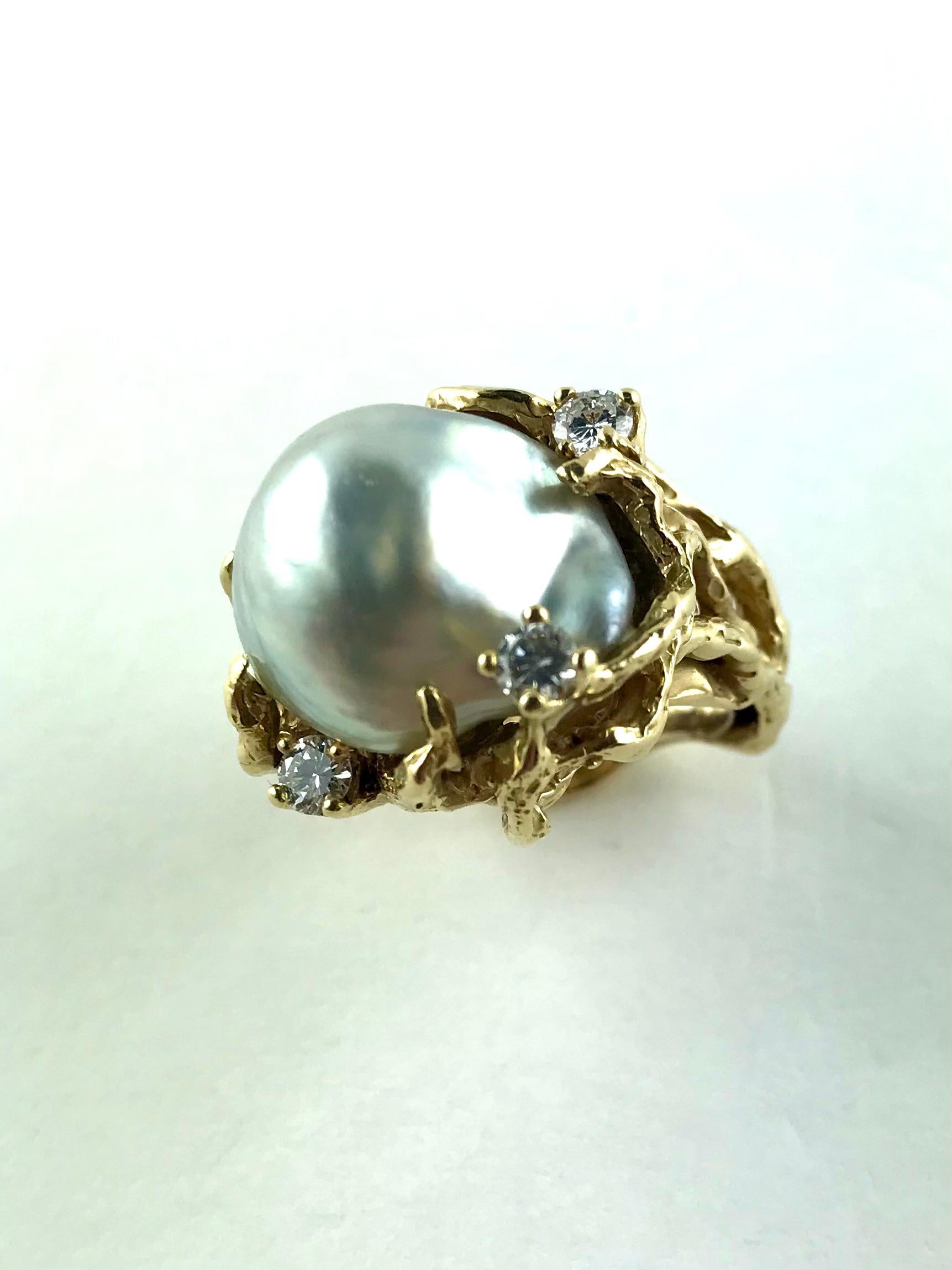 Extremely chic  1960s King cocktail Ring featuring a large South Sea Pearl. Set in 18k Yellow Gold, to the centre a silvery grey baroque Pearl with a splendid iridescent lustre and, to create the perfect light,  three round brilliant-cut Diamonds