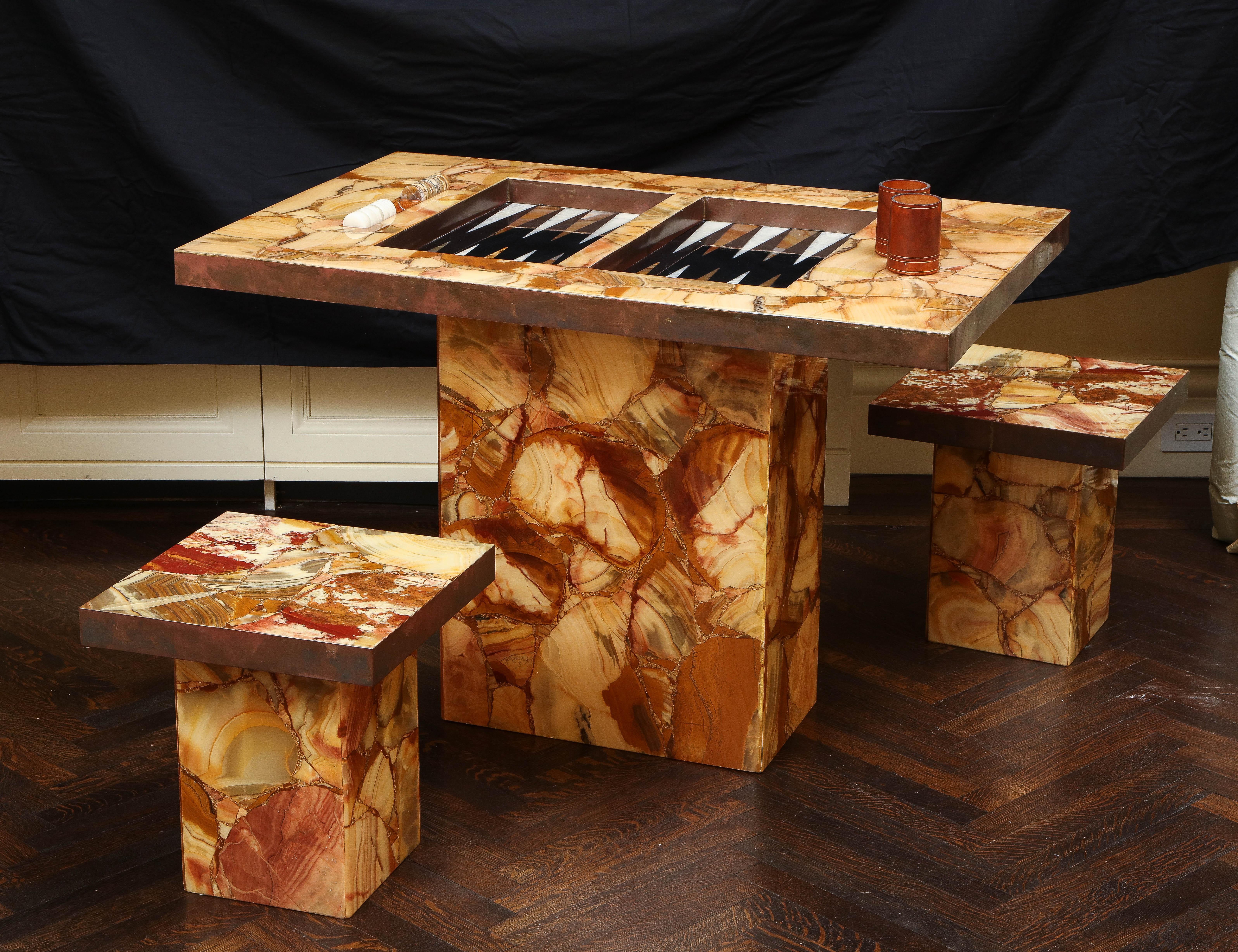 Artisan backgammon table and matching stools in onyx set in resin by Arturo Pani for Muller's of Mexico, 1960s. Table top and stool seats are wrapped in unlacquered brass banding. Includes original game pieces and cups. An exquisite set.