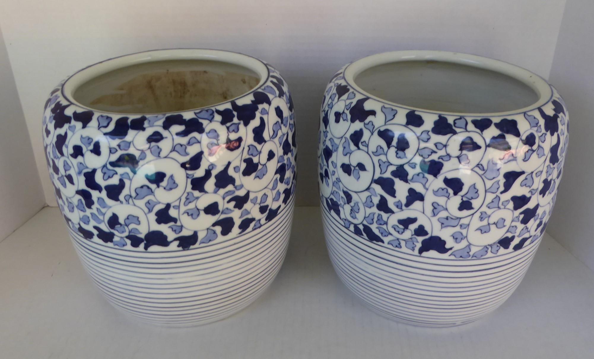 Asian modern pair of blue and white ceramic Japanese Hibachis. With a hand painted motif of winding vine with stylized dark and light blue leaves on the top 2/3 of the Hibachi and bands of blue in the bottom 1/3 on a white vitreous body.
A Hibachi