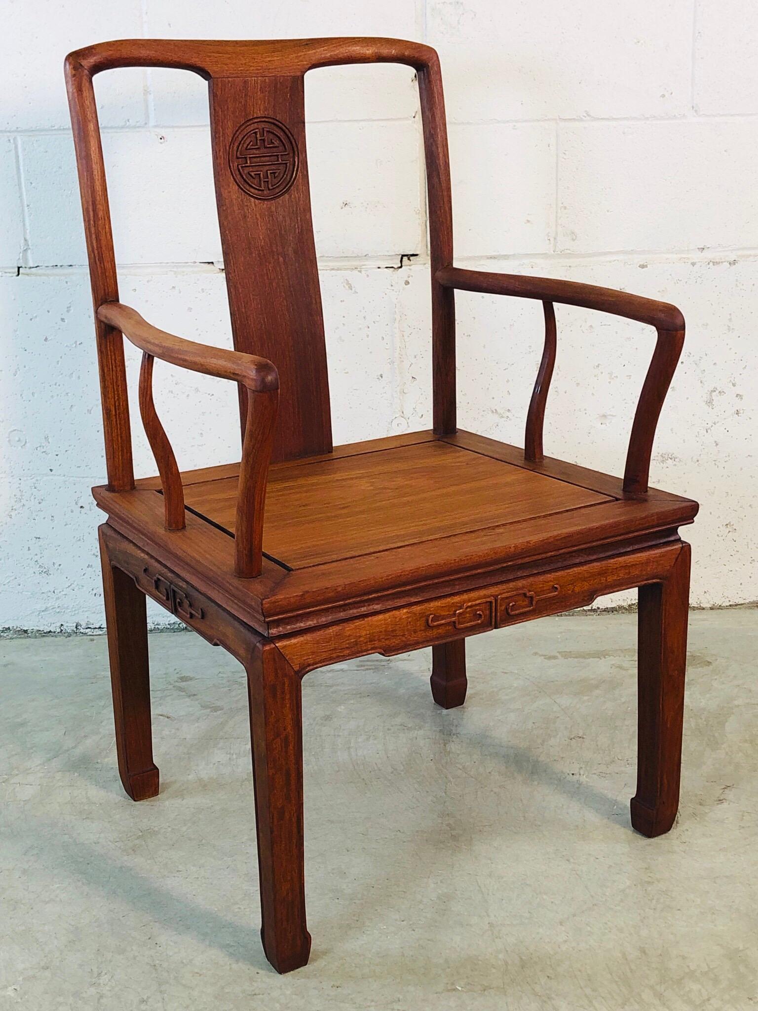 Mid-Century Modern 1960s Asian-Style teak hand carved arm chair. The chair has carved accents with curved arm details. Fully restored and refinished. No marks.