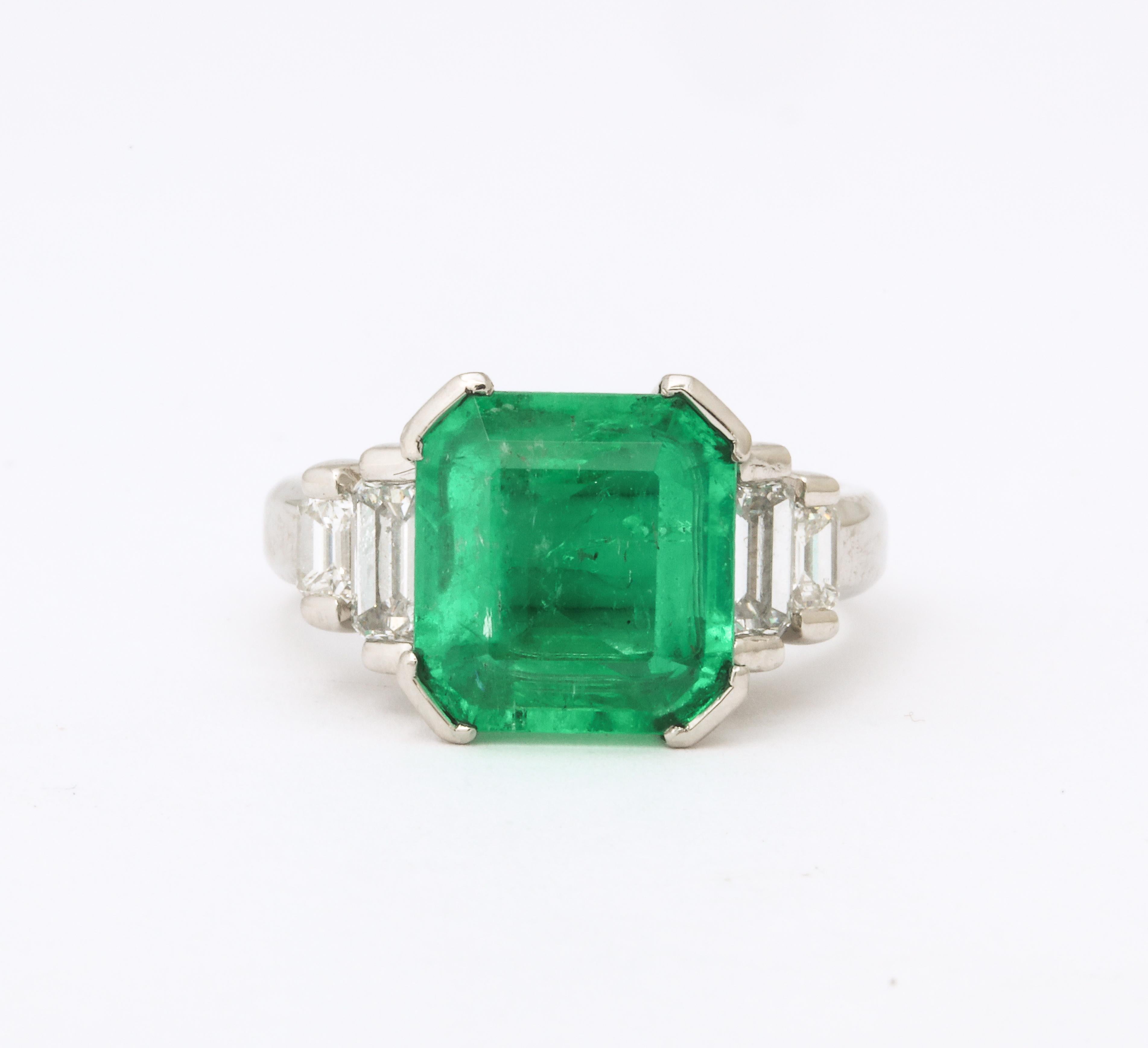 One Ladies Platinum Centering A 4.68 Carat Asscher Cut Emerald Origin Probably Colombian. Flanked By Four Stepdown Baguette Diamonds Weighing 1.01 Carats Total Weight. Crafted In America Circa 1960's.