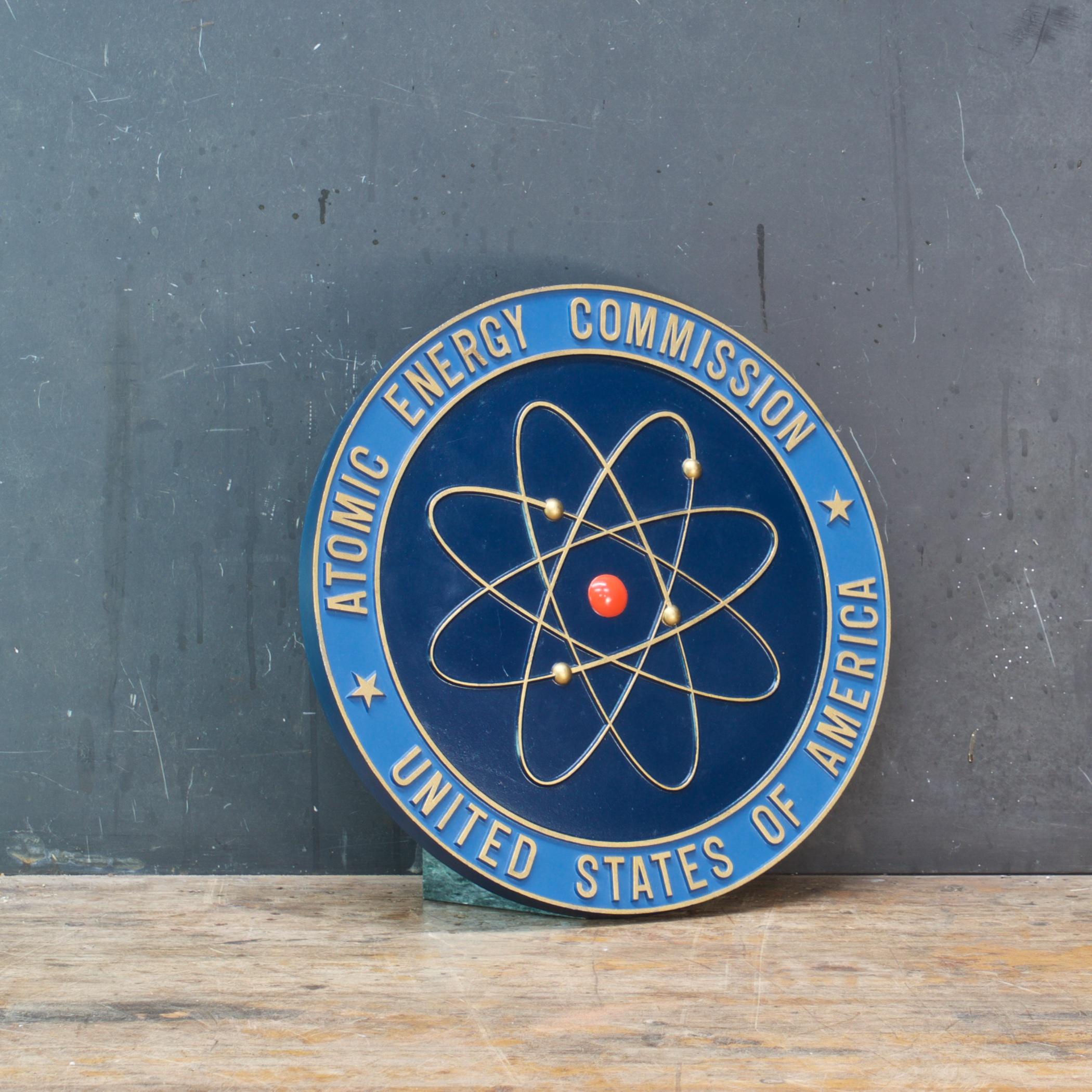 Das AEC-Siegel ist eines dieser großen Totems des Atomzeitalters. Die weitgehend symmetrische und stilisierte Darstellung eines Atoms (des hochgiftigen Berylliums) ist auffallend schlichter als die Siegel der Nachfolgeorganisationen. Das Design und
